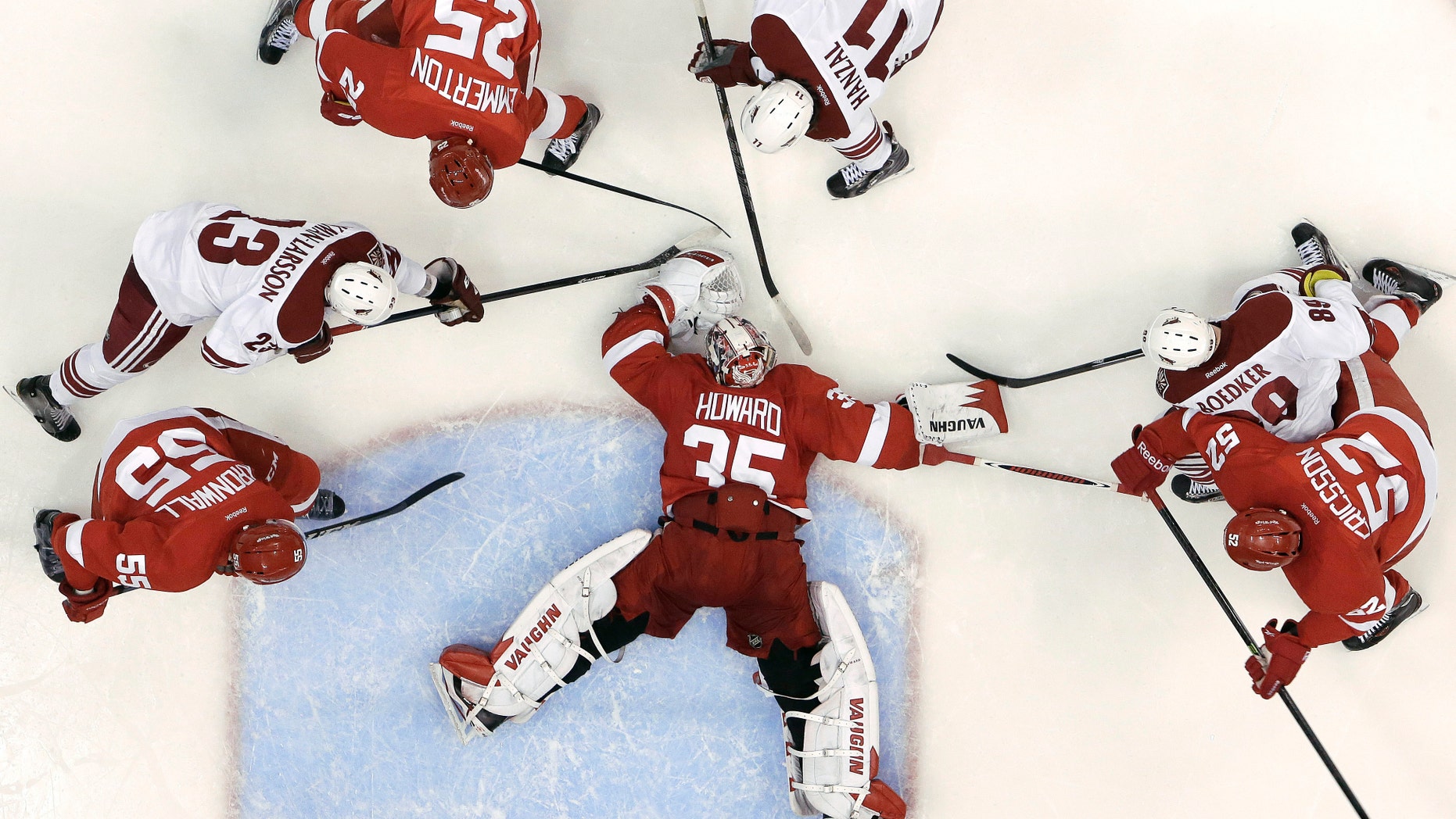 Detroit Red Wings goalie Jimmy Howard (35) covers the puck against the Phoenix Coyotes in the second period of an NHL hockey game in Detroit, Monday, April 22, 2013. Detroit won 4-0. (AP Photo/Paul Sancya)
