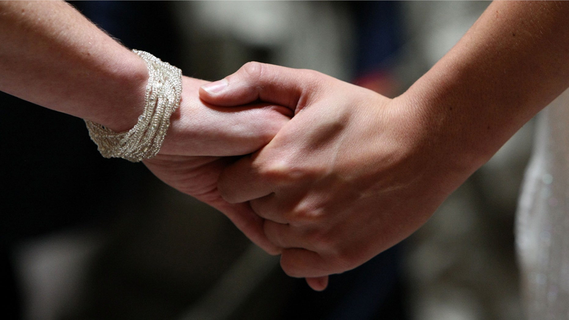 SAN FRANCISCO - JUNE 17: Same-sex couple Amber Weiss and Sharon Papo hold hands as they get married at San Francisco City Hall June 17, 2008 in San Francisco, California. Same-sex couples throughout California are rushing to get married as counties begin issuing marriage license after a State Supreme Court ruling to allow same-sex marriage. (Photo by Justin Sullivan/Getty Images)