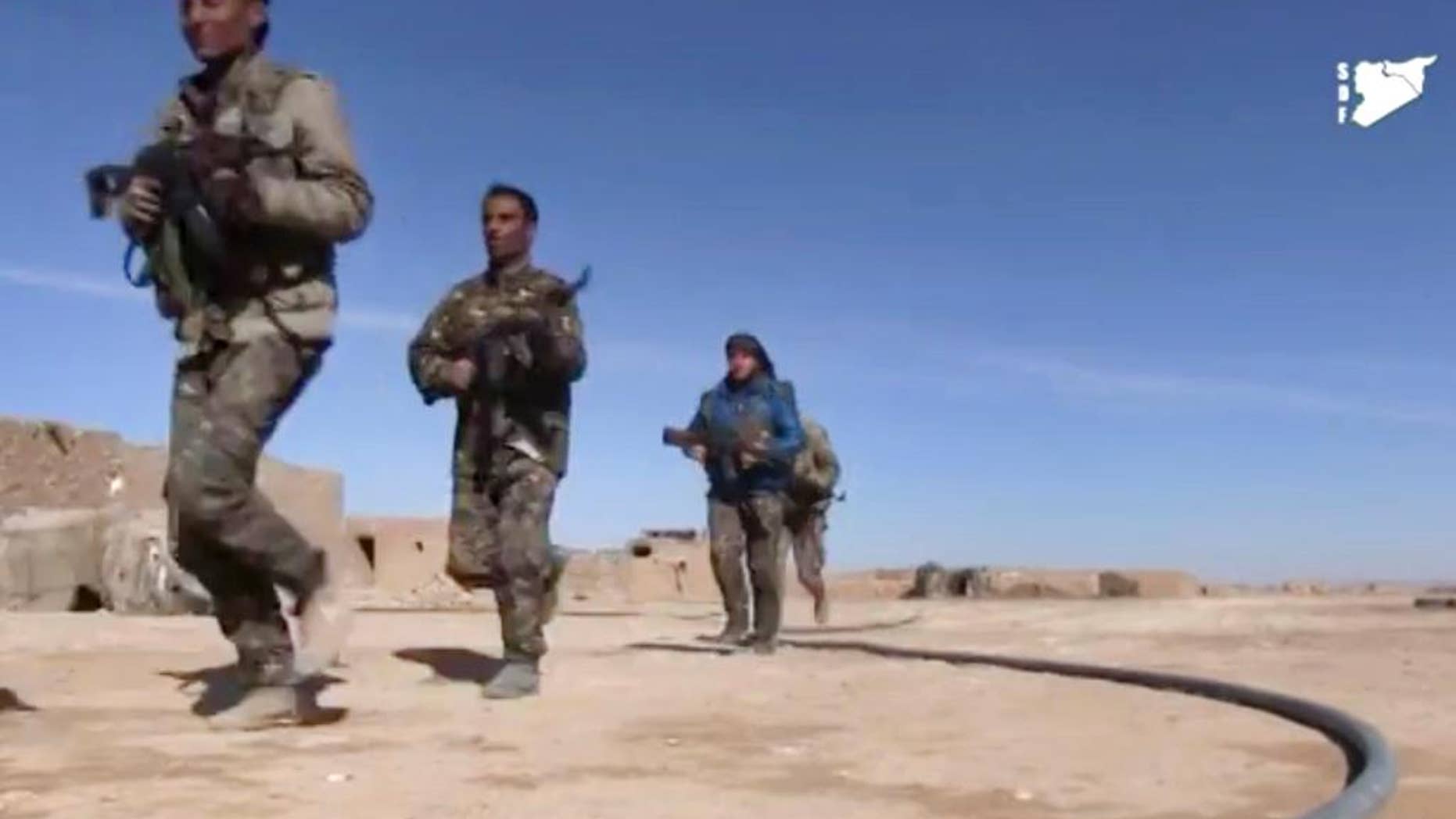 FILE - This frame grab from a video provided by the Syria Democratic Forces (SDF), shows fighters from the SDF running during fighting with Islamic State group militant, in Raqqa's eastern countryside, Syria, Monday, March 6, 2017. The main U.S.-backed force fighting the Islamic State group in Syria has enough fighters to capture the extremists' de facto capital of Raqqa north of the country at a time when U.S. troops are playing a bigger role on the ground in the battle to conquer the city, a spokeswoman for the force said Friday, March 10, 2017. (Syria Democratic Forces, via AP)