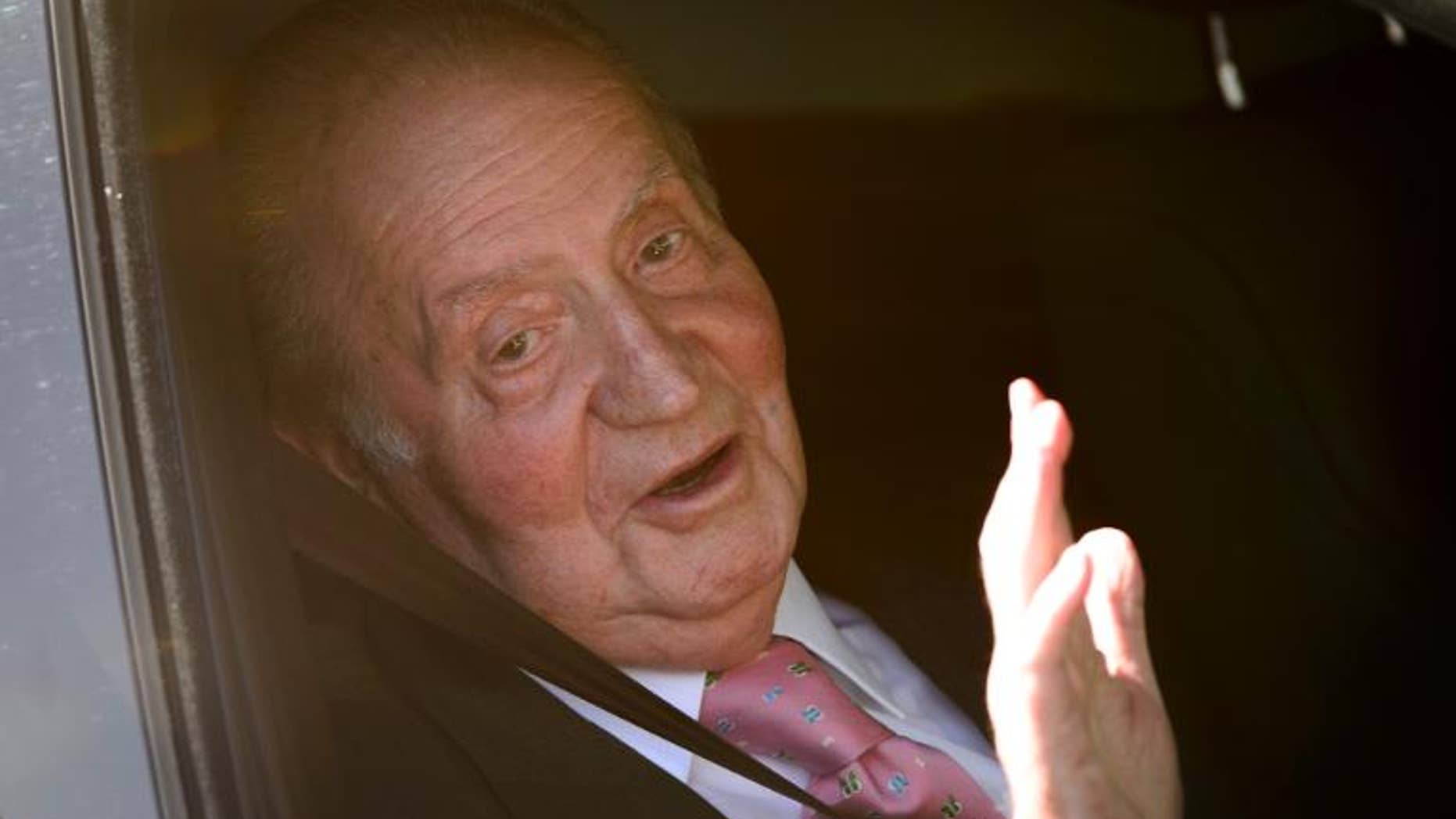 Spain's King Juan Carlos waves on arrival to the Quiron University Hospital in Madrid on September 24, 2013.
