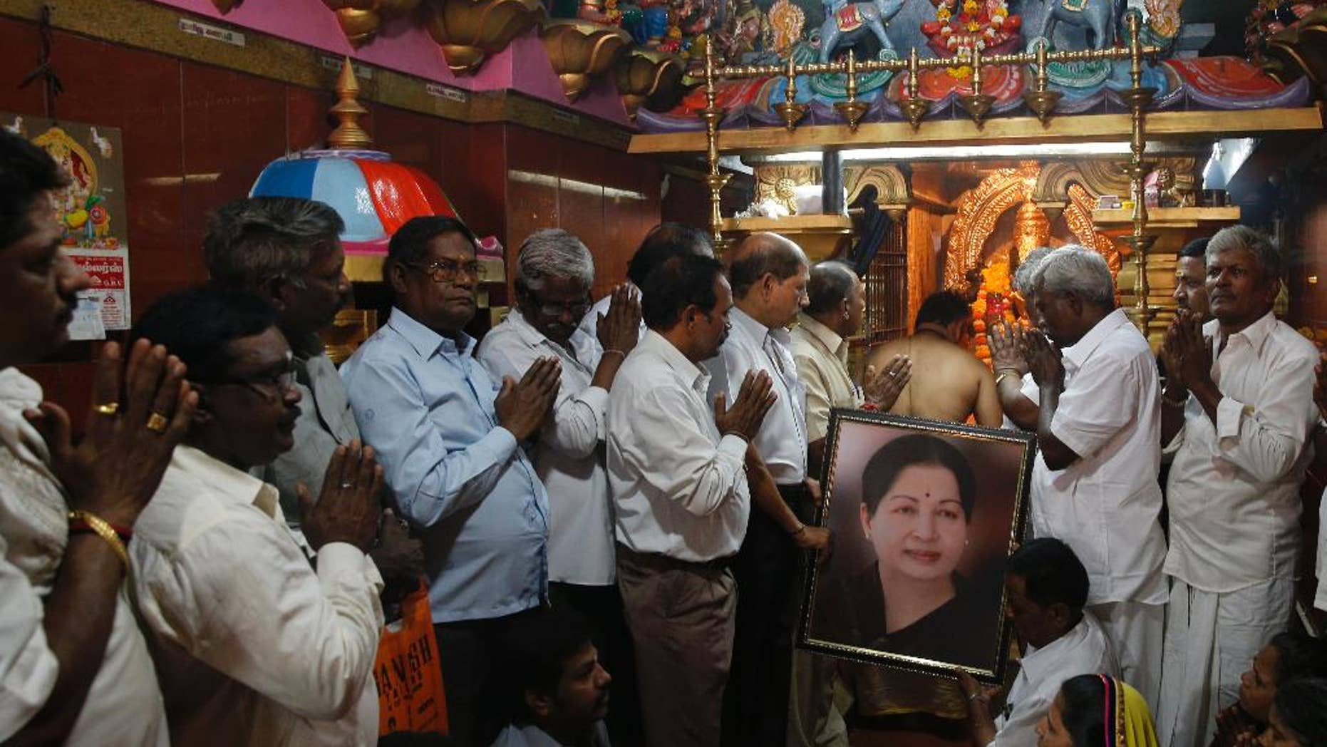 Supporters of Indian southern state of Tamil Nadu Chief Minister Jayalalithaa hold her photograph as they pray for her health at a temple in Mumbai, India, Monday, Dec. 5, 2016. Thousands of Jayalalitha supporters and well wishers across India prayed for her speedy recovery after she was readmitted to the hospital in Cheanni following a cardiac arrest on Sunday evening. (AP Photo/Rafiq Maqbool)