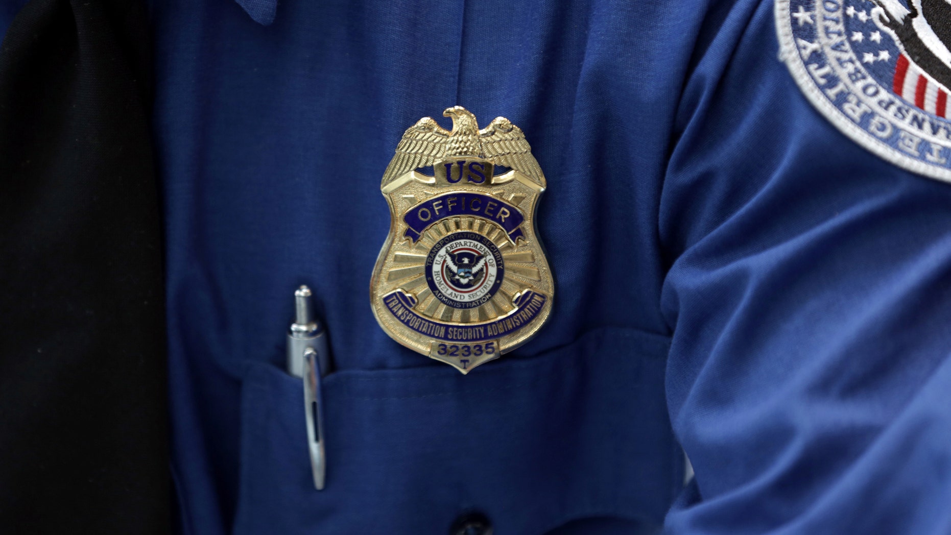 A Transportation Security Administration (TSA) official's wears a TSA badge at Terminal 4 of JFK airport in New York City, U.S., May 17, 2017. REUTERS/Joe Penney - RC1ADE93C100