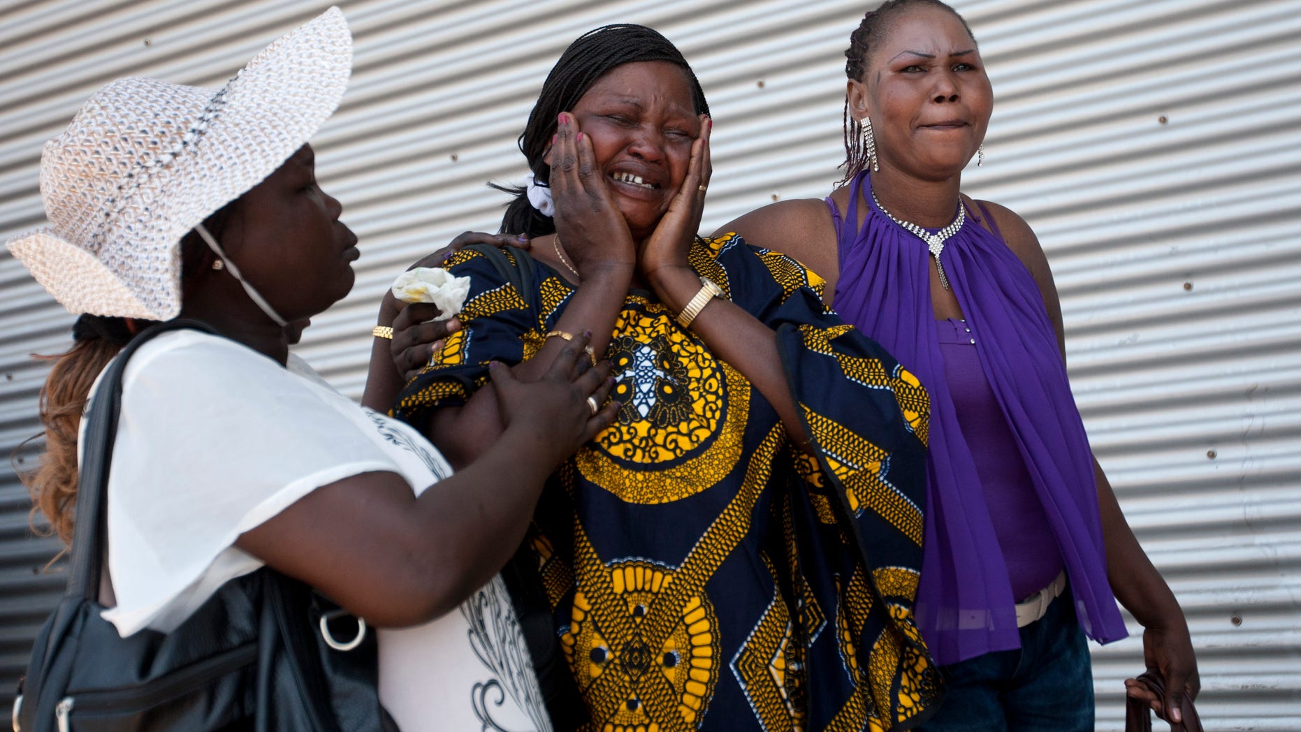 File - In this July 11, 2012 file photo, a South Sudanese migrant worker is comforted by her friends after two of her five children boarded a bus leaving to Ben Gurion airport enroute to South Sudan from Tel Aviv. Israel has quietly repatriated hundreds of Sudanese migrants in recent months, drawing accusations from the United Nations and rights groups that it has coerced the Africans into potentially life-threatening situations and possibly violated international norms for treating refugees. (AP Photo/Ariel Schalit, File)