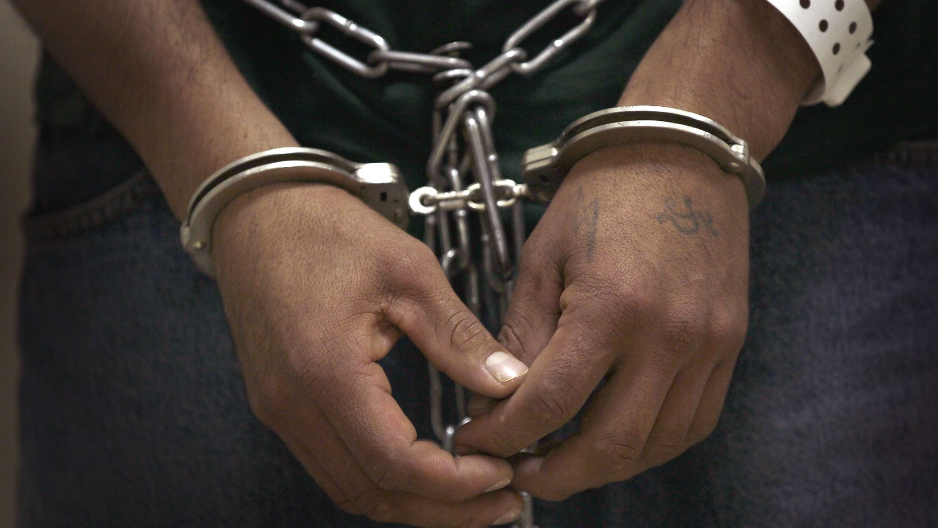 BROADVIEW, IL - MAY 25: An undocumented immigrant stands cuffed and shackled at the U.S. Immigration and Customs Enforcement (ICE) processing facility before he and other undocumented immigrants were transported to the airport for a deportation flight May 25, 2010 in Broadview, Illinois. The immigrants at the suburban Chicago facility were flown by charter flight to Harlingen, Texas where they were then bussed to Brownsville and finally walked to the Mexican border and released from custody. The U.S. deports over 350,000 immigrants a year for entering the country illegally, most are Mexican, and more than 90 percent are men. (Photo by Scott Olson/Getty Images)