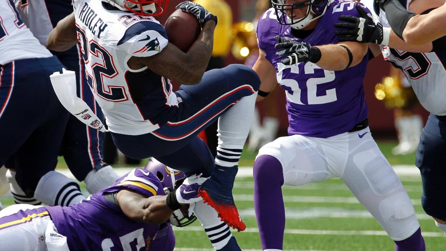 New England Patriots running back Stevan Ridley (22) carries the ball as Minnesota Vikings linebacker Jasper Brinkley and linebacker Chad Greenway (52) defend during the first quarter of an NFL football game Sunday, Sept. 14, 2014, in Minneapolis. (AP Photo/Ann Heisenfelt)