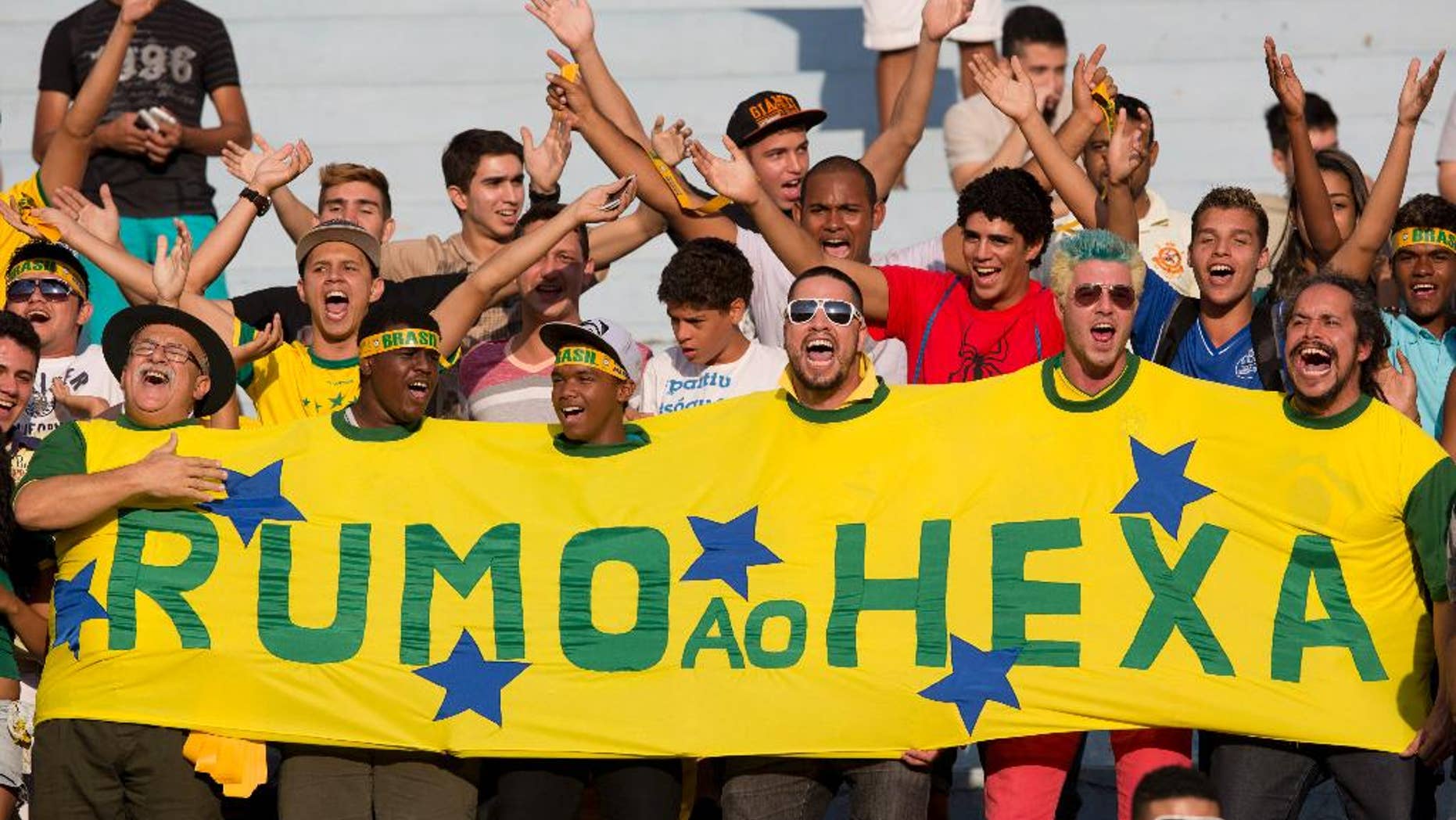 Brazil's supporters cheer in the stands during a team practice session at the Serra Dourada stadium in Goiania, Brazil, Monday, June 2, 2014. The banner reads in Portuguese "On its way to the sixth", referring to Brazil's five past World Cup titles and hope for a sixth this year. Brazil will face Panama on Tuesday in preparation for the World Cup soccer tournament that starts on 12 June. (AP Photo/Andre Penner)