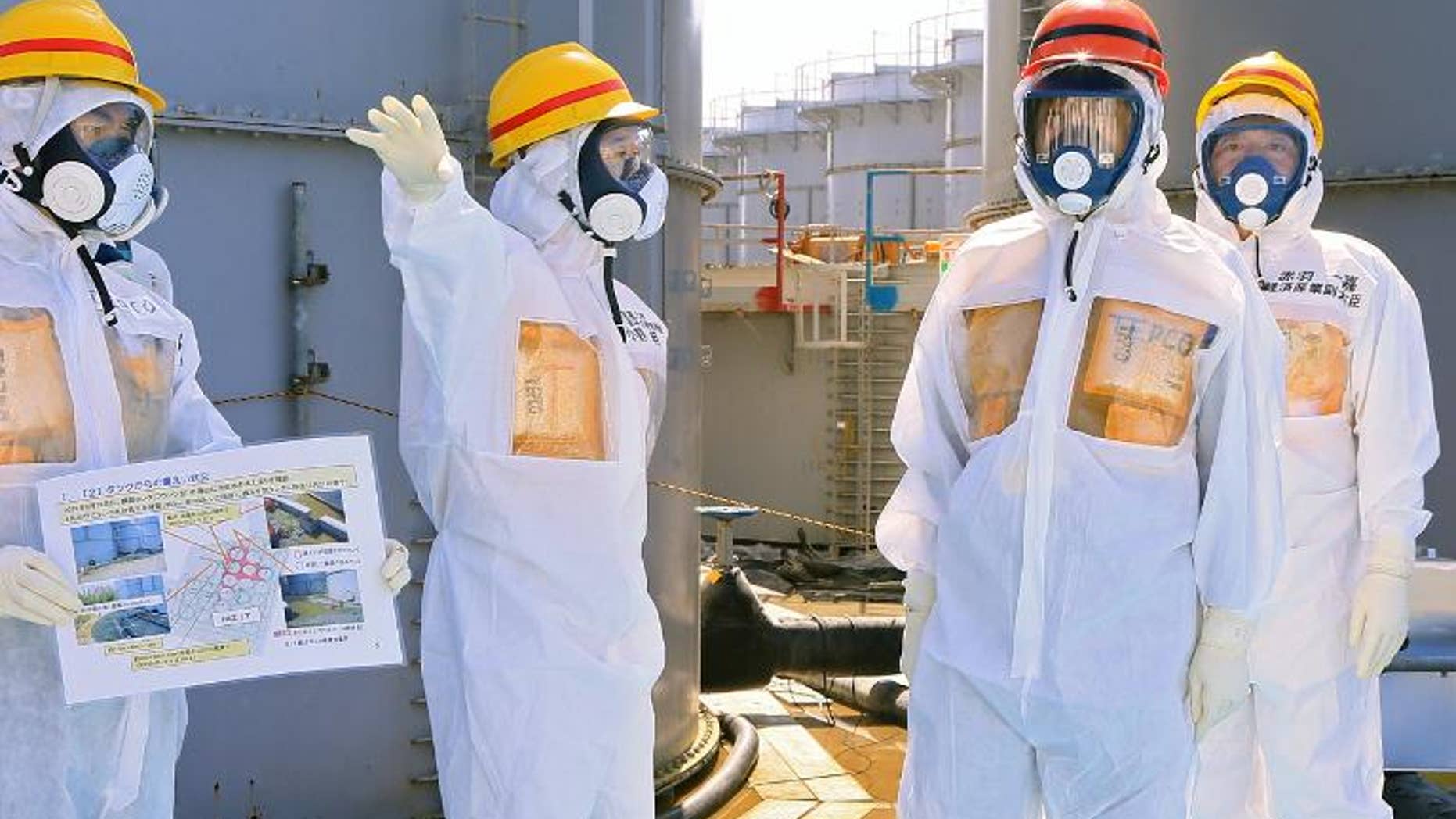 Japanese Prime Minister Shinzo Abe (second right) is briefed during his tour to the tsunami-crippled Fukushima nuclear plant in Okuma, northeastern Japan on September 19, 2013