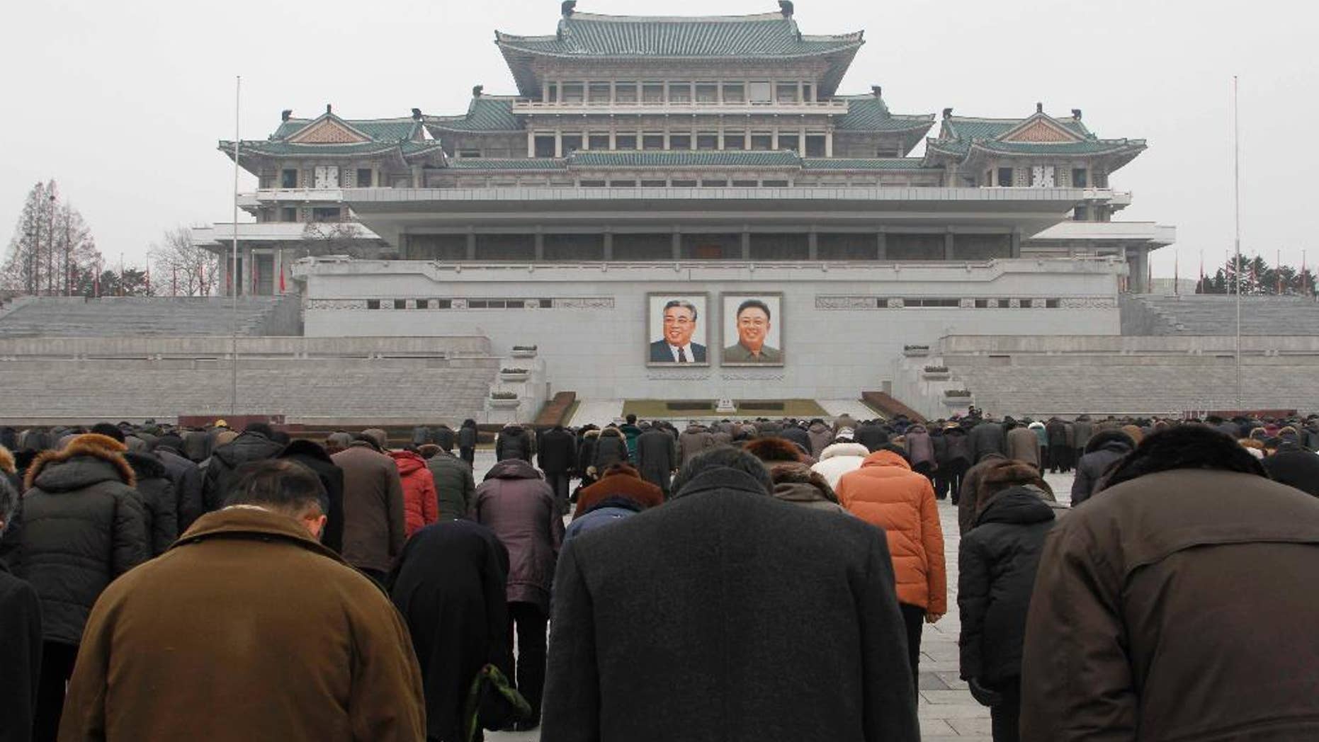 People offer three minutes of silence in front of portraits of the late leaders Kim Il Sung, left, and Kim Jong Il at the Kim Il Sung Square in Pyongyang, North Korea, Saturday, Dec. 17, 2016, to mark the fifth anniversary of Kim Jong Il's death. It’s been five years since North Korean leader Kim Jong Un took power following the death of his father, Kim Jong Il, whose demise was observed at monuments and on city center plazas across the nation Saturday. (AP Photo/Kim Kwang Hyon)