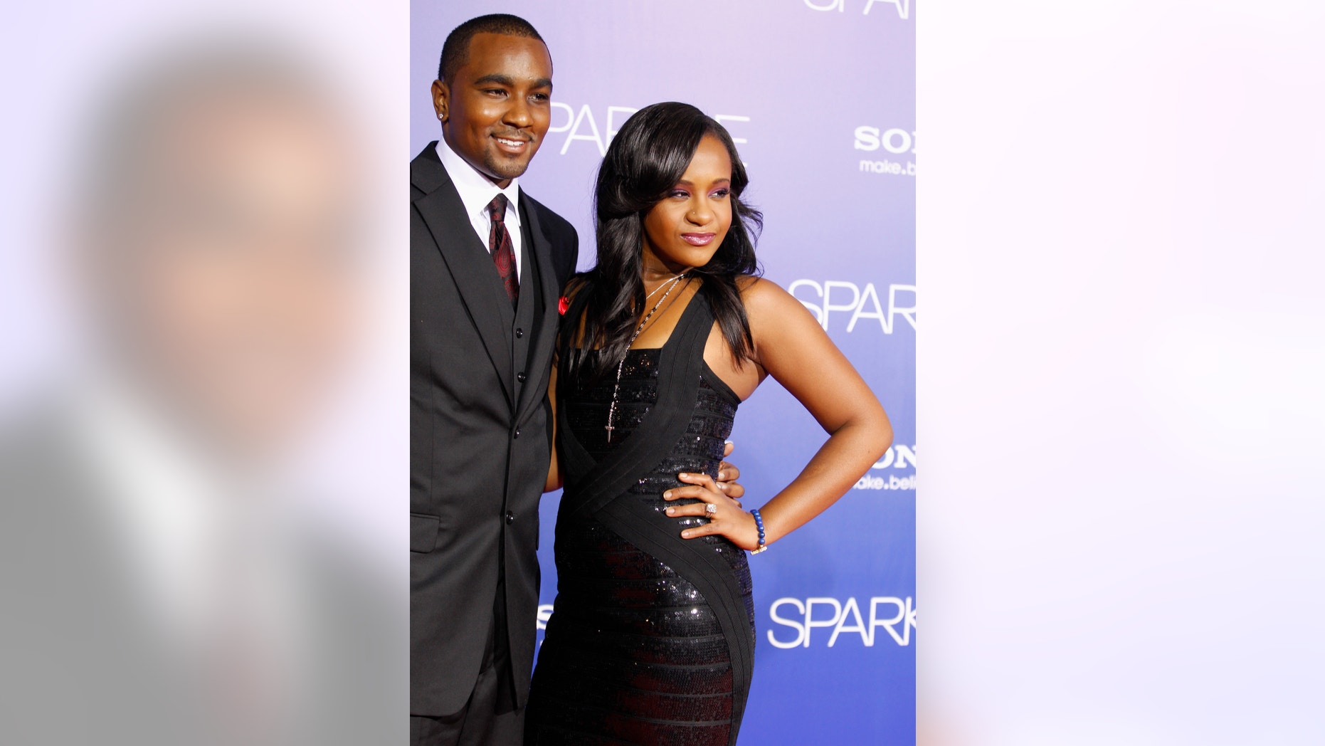 Bobbi Kristina Brown, daughter of the late singer Whitney Houston, reveals a tattoo with the initials "W H" as she waves while arriving with boyfriend Nick Gordon at the premiere of the new film "Sparkle" starring Jordin Sparks and the late Whitney Houston in Hollywood August 16, 2012.