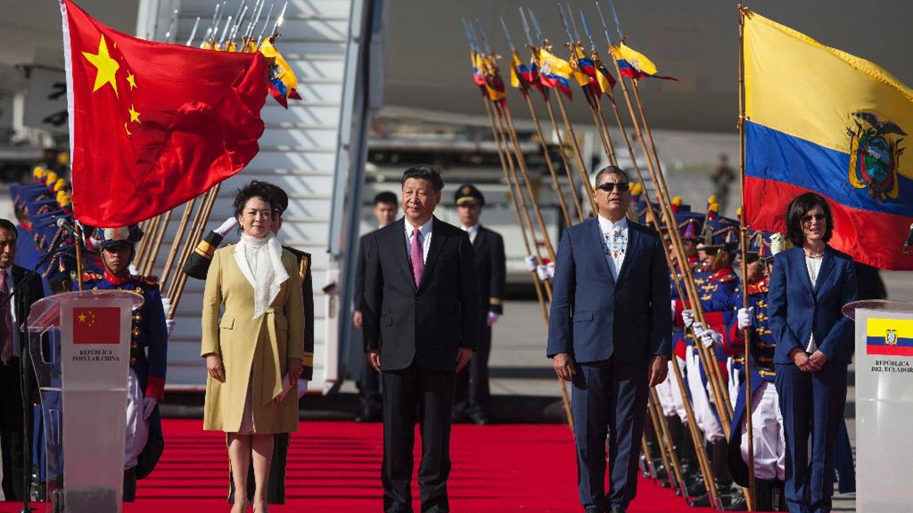 China's President Xi Jinping, center, and his wife Peng Liyuan stand with Ecuador's President Rafael Correa, second from right, during a welcoming ceremony at Mariscal Sucre Airport in Quito, Ecuador, Thursday, Nov. 17, 2016. Xi Jinping is in Ecuador for two days before heading to Peru for the APEC summit. (AP Photo/Ana Buitron)