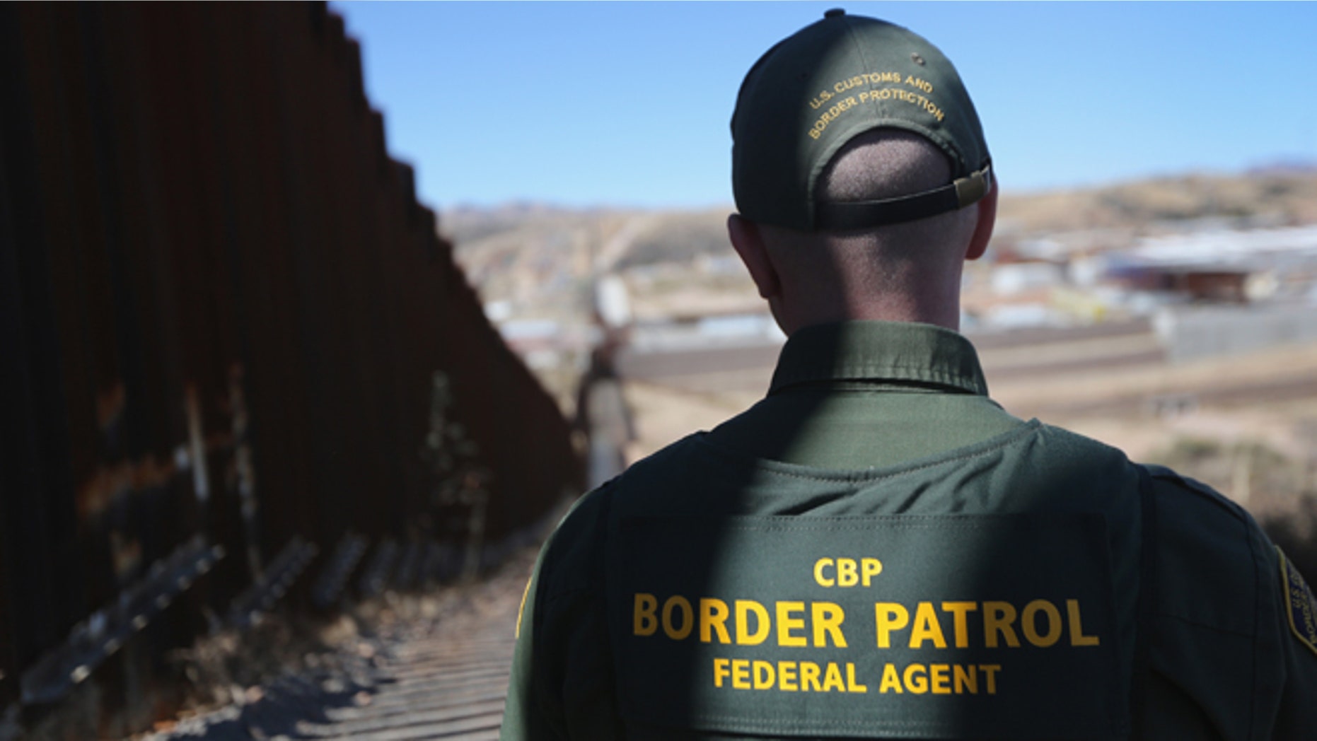 NOGALES, AZ - FEBRUARY 26: A U.S. Border Patrol agent looks along a section of the recently-constructed fence at the U.S.-Mexico border on February 26, 2013 in Nogales, Arizona. The new fencing, which ranges from 18-32 feet high in the Nogales area, allows Border Patrol agents to see through the fence and is harder for immigrants or drug smugglers to scale from the Mexican side. (Photo by John Moore/Getty Images)