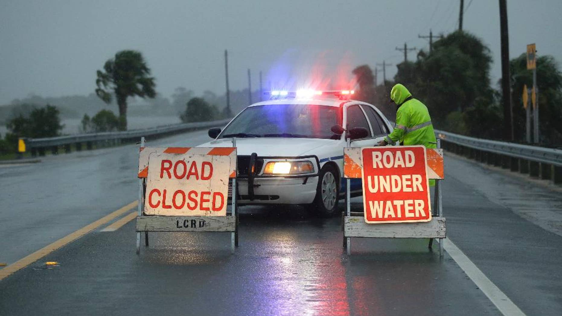 Police block the road entering Cedar Key, Fla., as Hurricane Hermine nears the Florida coast, Thursday, Sept. 1, 2016. Hurricane Hermine gained new strength Thursday evening and roared ever closer to Florida's Gulf Coast, where rough surf began smashing against docks and boathouses and people braced for the first direct hit on the state from a hurricane in over a decade. (AP Photo/John Raoux)