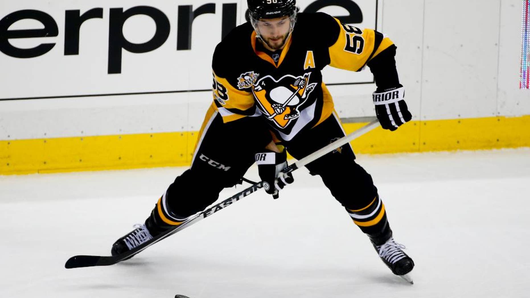 FILE- In this Feb. 3, 2017, file photo, Pittsburgh Penguins' Kris Letang makes a pass during the first period of an NHL hockey game against the Columbus Blue Jackets in Pittsburgh. The Penguins will head into the Stanley Cup playoffs without Letang, who is scheduled to undergo surgery to repair a herniated disk in his neck and will be out four to six months. (AP Photo/Gene J. Puskar, File)