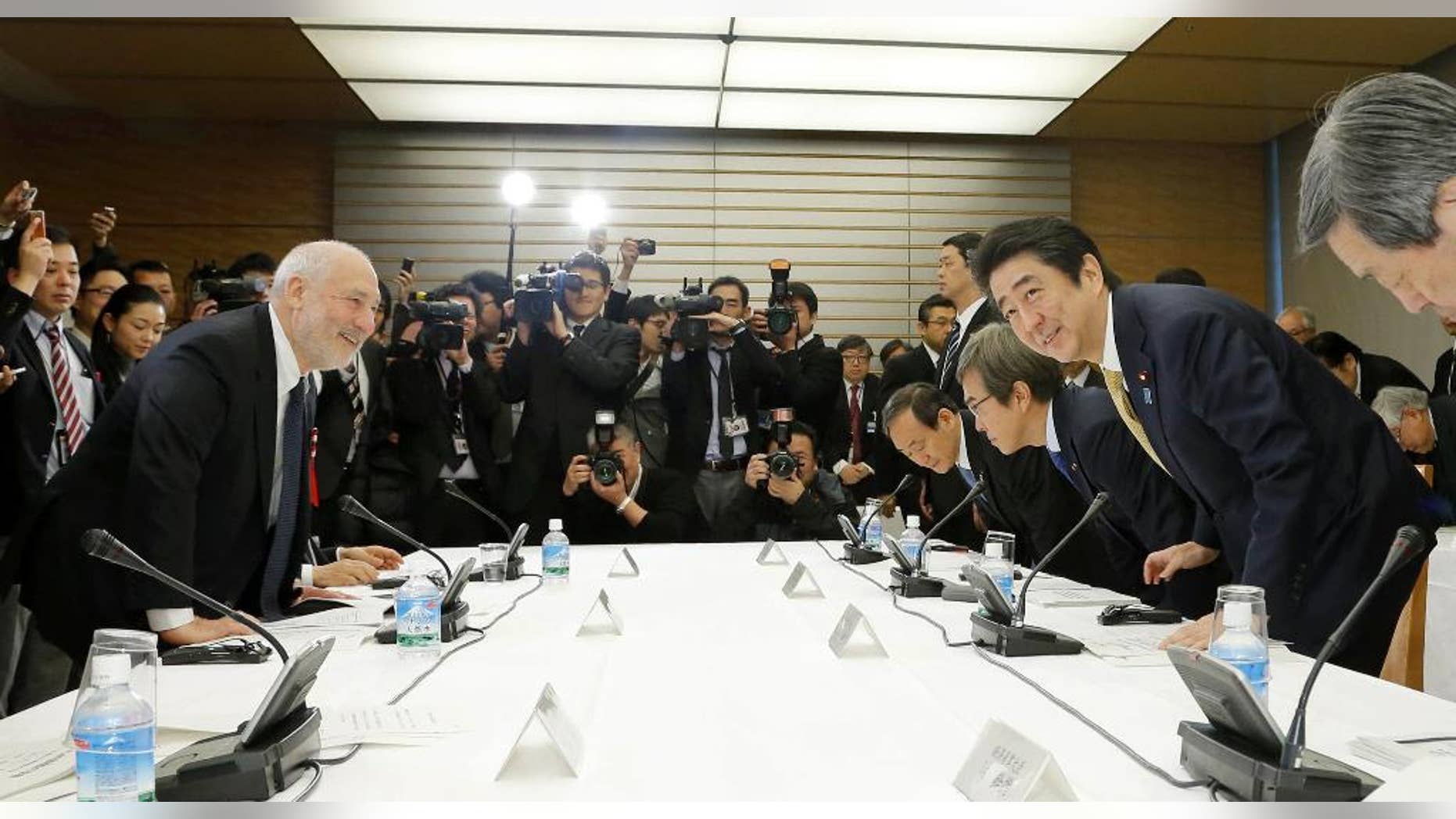 In this March 16, 2016 photo, Japanese Prime Minister Shinzo Abe, second from right, and Nobel laureate economist Joseph Stiglitz, left, take their seats for an economic seminar with other members of his Cabinet at Abe's official residence in Tokyo. The message: no matter how bad the debt, Japan's economy is too weak to withstand another tax hike. All is not well in Abenomics land, the world’s third-largest economy, and Abe is seeking fresh advice from top experts, both foreign and Japanese, on what to do next. (Kazunari Fujikake/Kyodo News via AP) JAPAN OUT, MANDATORY CREDIT