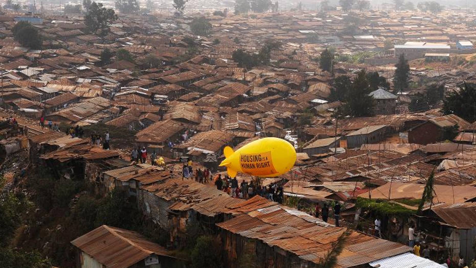 Members of NGO Amnesty International carry a hot air balloon with text which reads 'Housing is a Human right' through the Kibera slum in Nairobi on March 24, 2012
