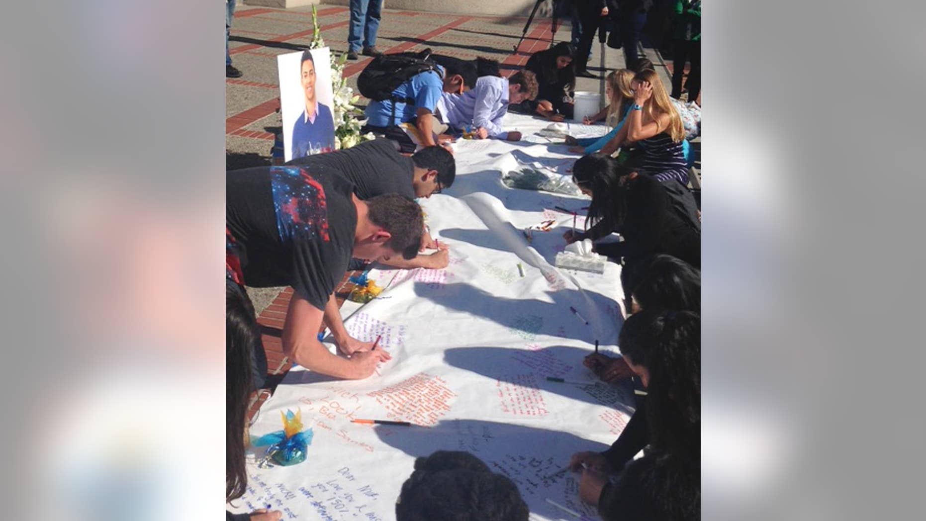 Students leave condolences on a banner for Nicolas Leslie, who was killed in France last week, during a vigil at the University of California, Berkeley Monday, July 18, 2016 in Berkeley, Calif. Leslie, 20, a Berkeley student who was killed in last week's Bastille Day truck attack in France was remembered Monday as an energetic and engaged member of the campus community. Leslie was an aspiring entrepreneur and environmentalist who participated in fraternity life and a student-run consulting group that provides marketing, research and social responsibility advice to businesses, student body President William Morrow said. (AP Photo/Lisa Leff)