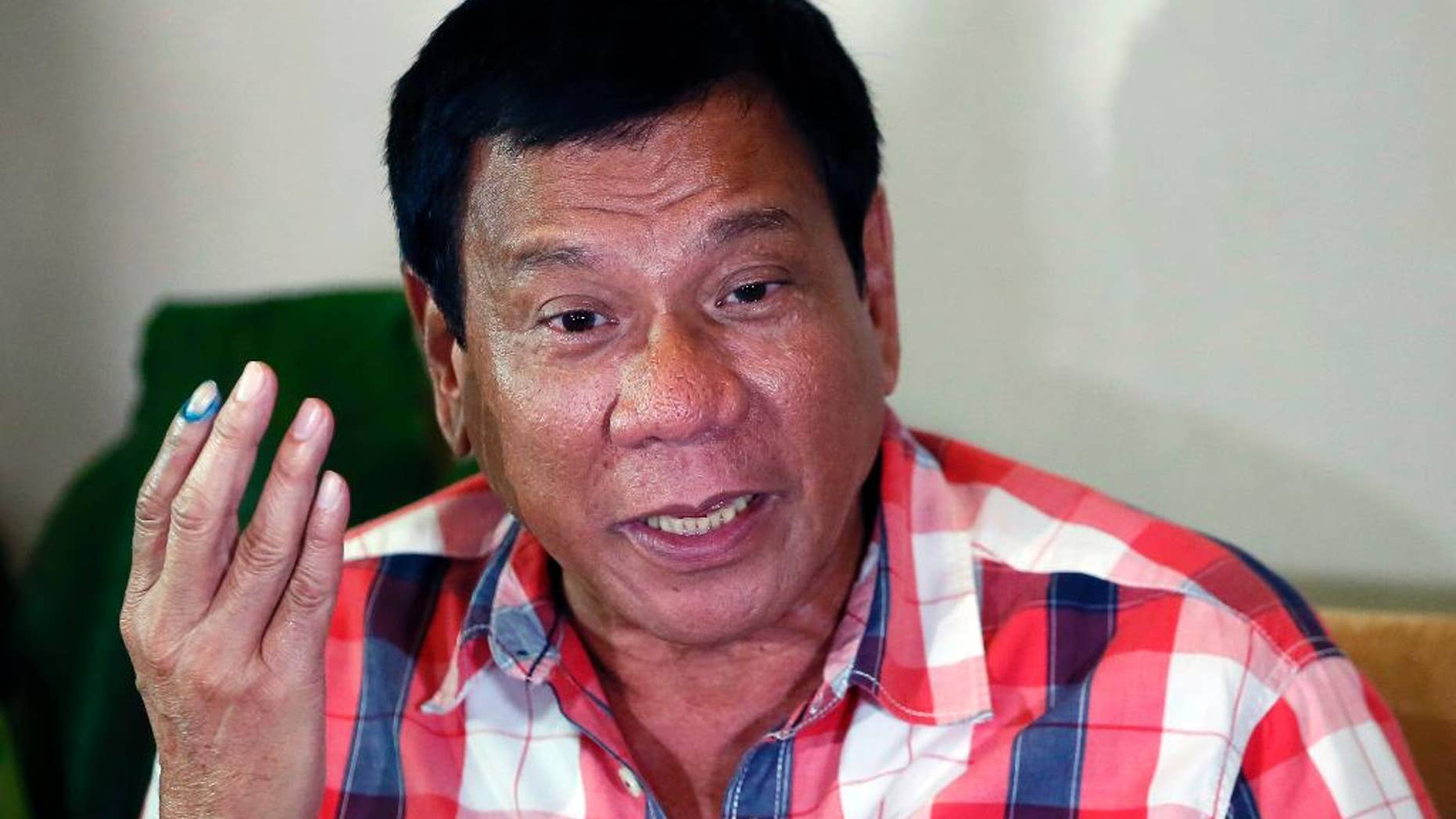 FILE- In this May 9, 2016 file photo, then front-running presidential candidate Mayor Rodrigo Duterte gestures during a news conference in Davao city in southern Philippines. The Philippine president-elect Rodrigo Duterte said Tuesday, June 21, 2016 he recently asked the U.S. ambassador whether Washington will support the Philippines in case of a possible confrontation with China in the disputed South China Sea. (AP Photo/Bullit Marquez, File)