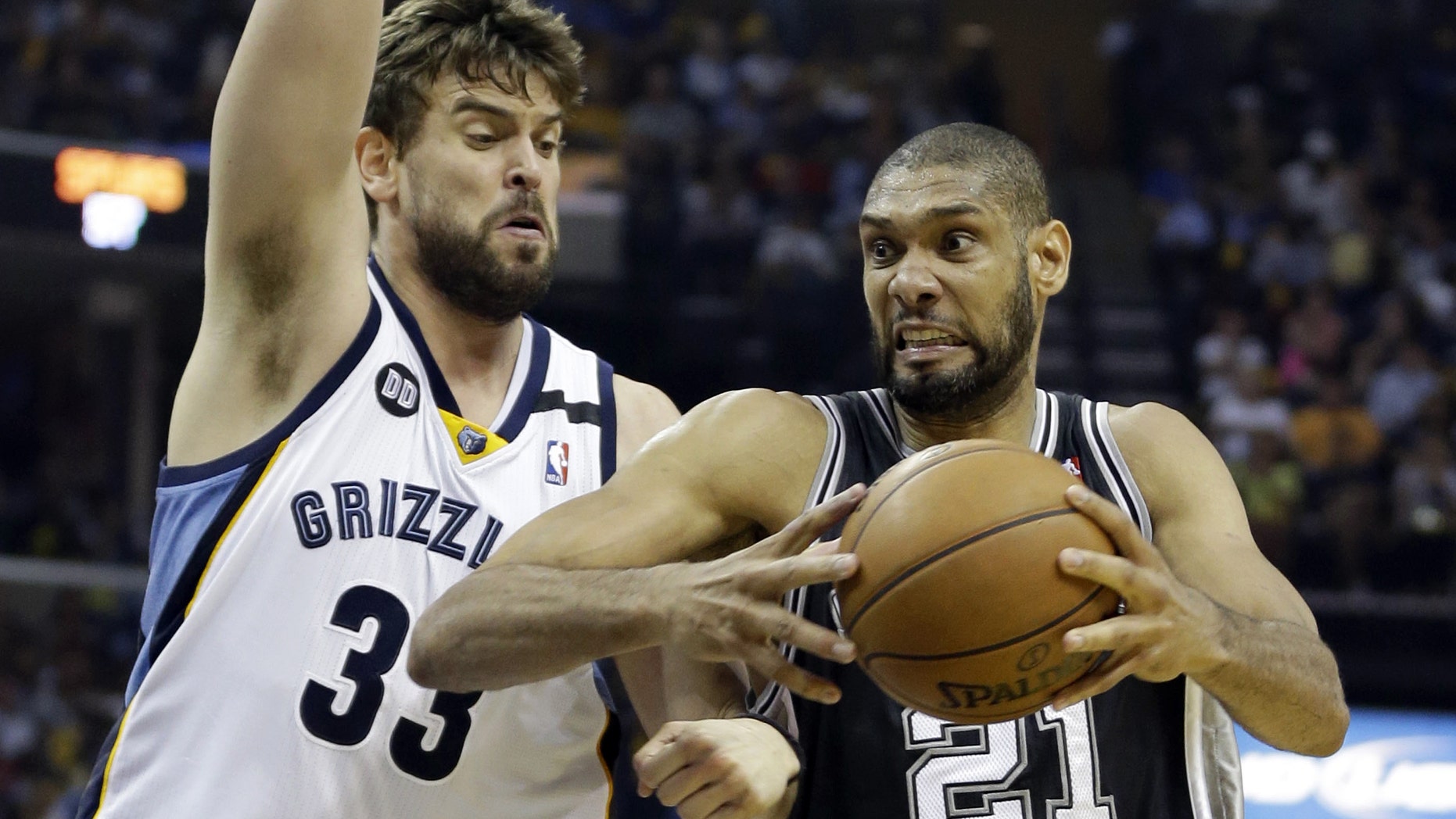 San Antonio Spurs forward Tim Duncan (21) drives to the basket as Memphis Grizzlies center Marc Gasol (33) defends, during Game 4 of the Western Conference finals NBA basketball playoff series in Memphis, Tenn., Monday, May 27, 2013. The Spurs defeated the Grizzlies 93-86 to advance to the NBA finals. (AP Photo/Danny Johnston)