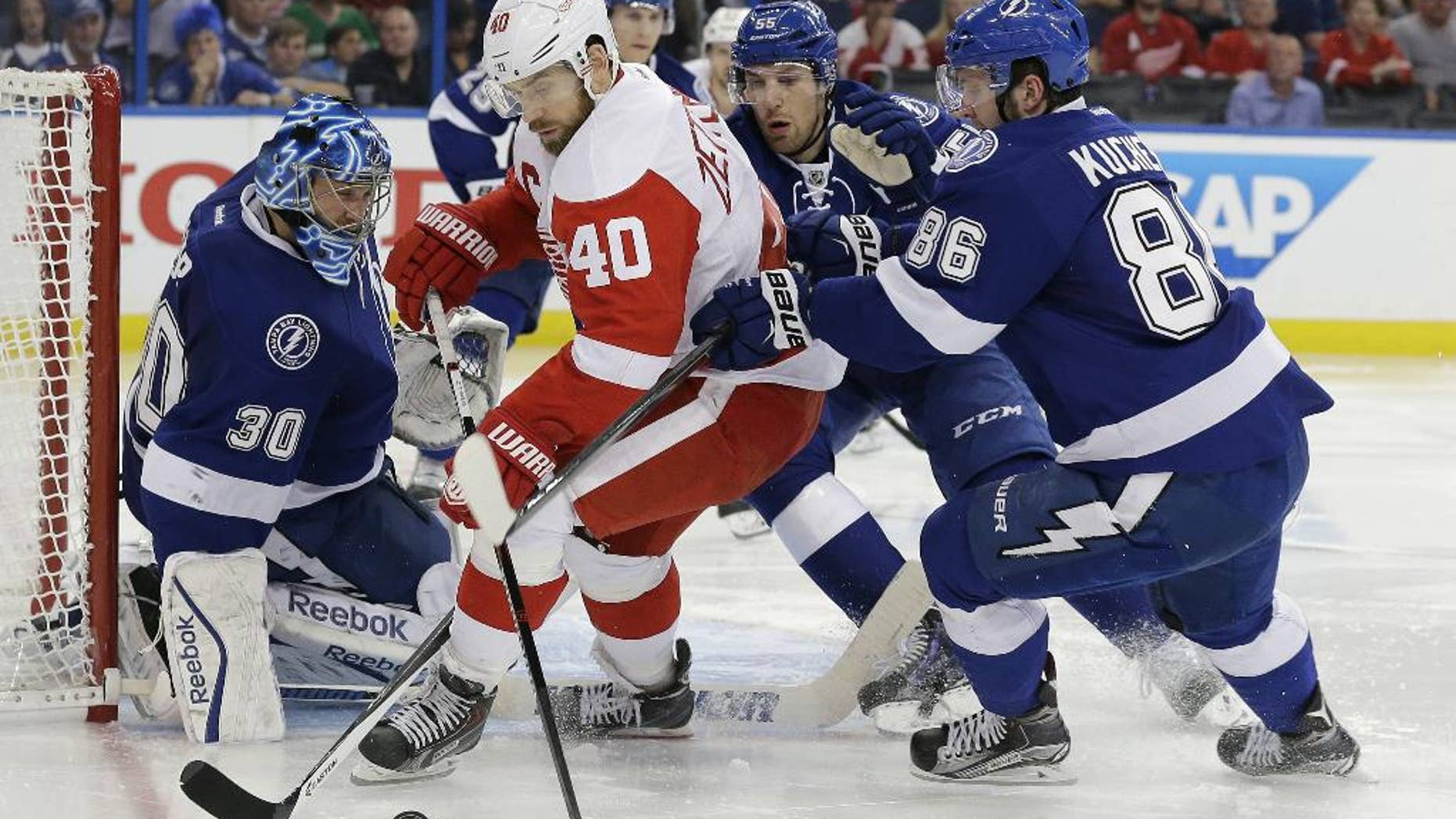 Detroit Red Wings left wing Henrik Zetterberg (40), of Sweden, is stopped by Tampa Bay Lightning goalie Ben Bishop (30), defenseman Braydon Coburn (55) and right wing Nikita Kucherov (86), of Russia, during the third period of Game 2 of a first-round NHL Stanley Cup hockey playoff series Saturday, April 18, 2015, in Tampa, Fla. The Lightning won the game 5-1. (AP Photo/Chris O'Meara)