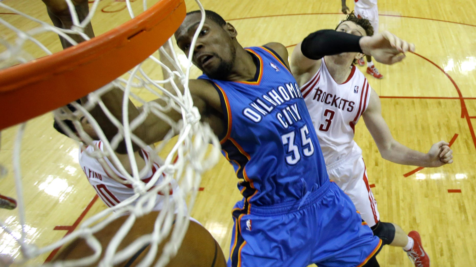 Oklahoma City Thunder's Kevin Durant (35) dunks the ball as Houston Rockets' Omer Asik (3) defends during the second half of Game 4 in a first-round NBA basketball playoff series Monday, April 29, 2013, in Houston. The Rockets beat the Thunder 105-103. (AP Photo/David J. Phillip)