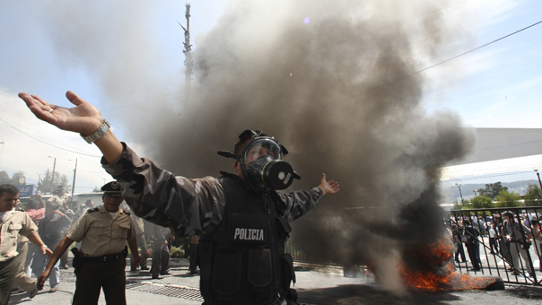 Sept. 30: A police officer demonstrates next to a bonfire during a protest of police officers and soldiers against a new law that cuts their benefits at a police base in Quito, Ecuador.
