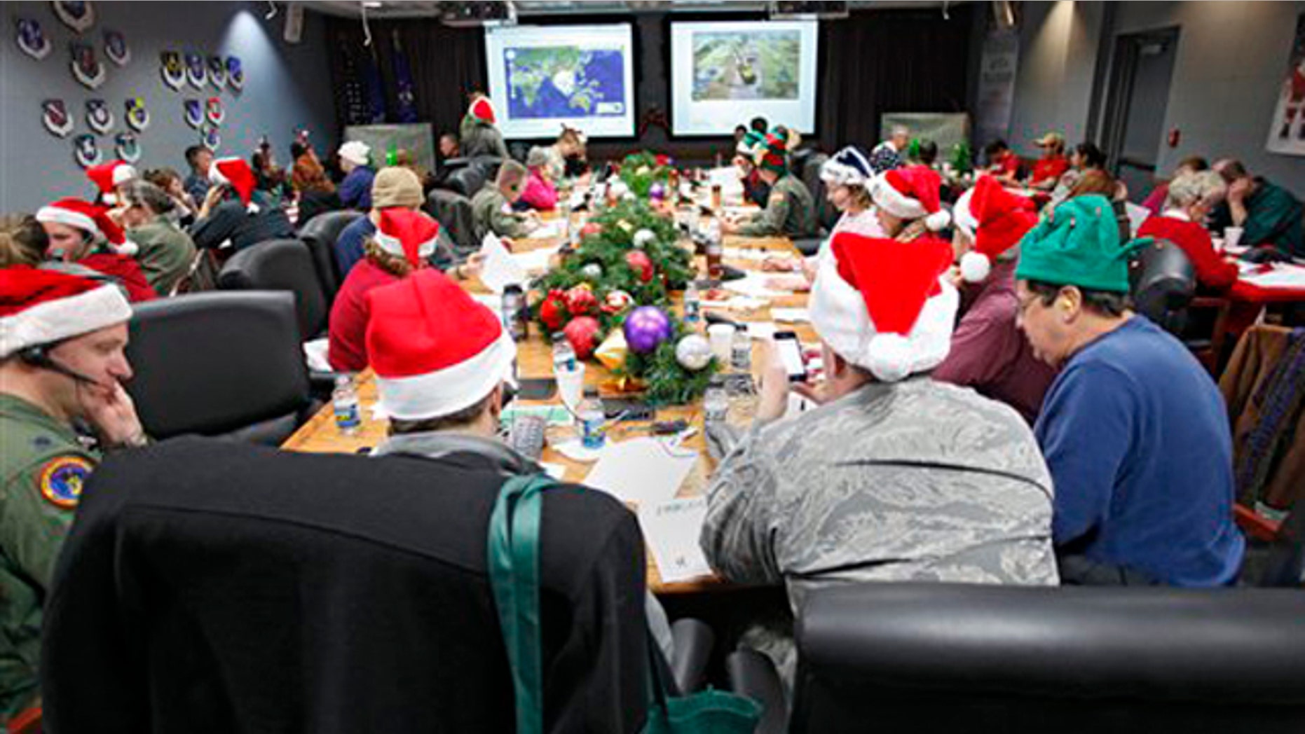 FILE - In this Dec. 24, 2010 file photo, volunteers take phone calls and answer emails at the Santa Tracking Operations Center at Peterson Air Force Base near Colorado Springs, Colo. Santa is already piling up monster numbers on social networking sites this season, so the volunteer Santa-trackers at NORAD are bracing for tens of thousands of calls and emails when their operations center goes live on Christmas Eve. (AP Photo/Ed Andrieski, File)