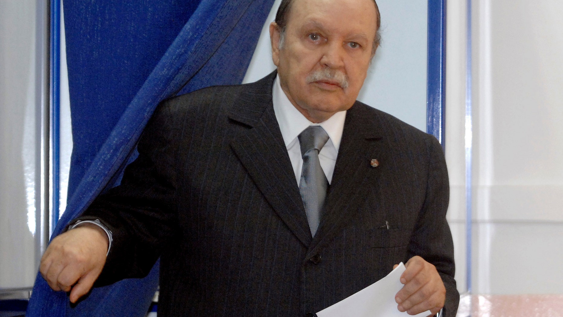 FILE - This May, 10, 2012 file photo shows Algerian President Abdelaziz Bouteflika exiting a parliamentary election voting booth in Algiers. Algeria's presidency says the country's ailing president has been in a Paris military hospital since Monday for a routine checkup and his condition is improving. Abdelaziz Bouteflika suffered a stroke in April and was hospitalized for four months in Paris' Val-de-Grace hospital. He has seemed visibly weak in rare television appearances since then. (AP Photo/Sidali Djarboub, File)
