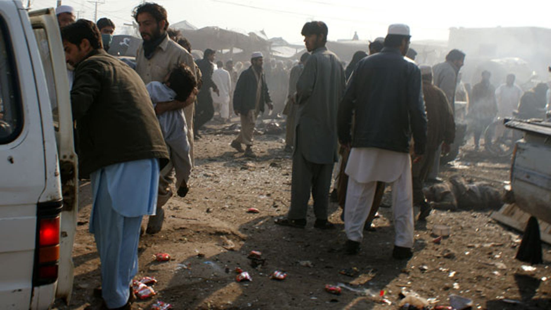 Jan. 10, 2012: A man carries an injured person to a vehicle after an explosion in Pakistani tribal area of Khyber near Peshawar, Pakistan.