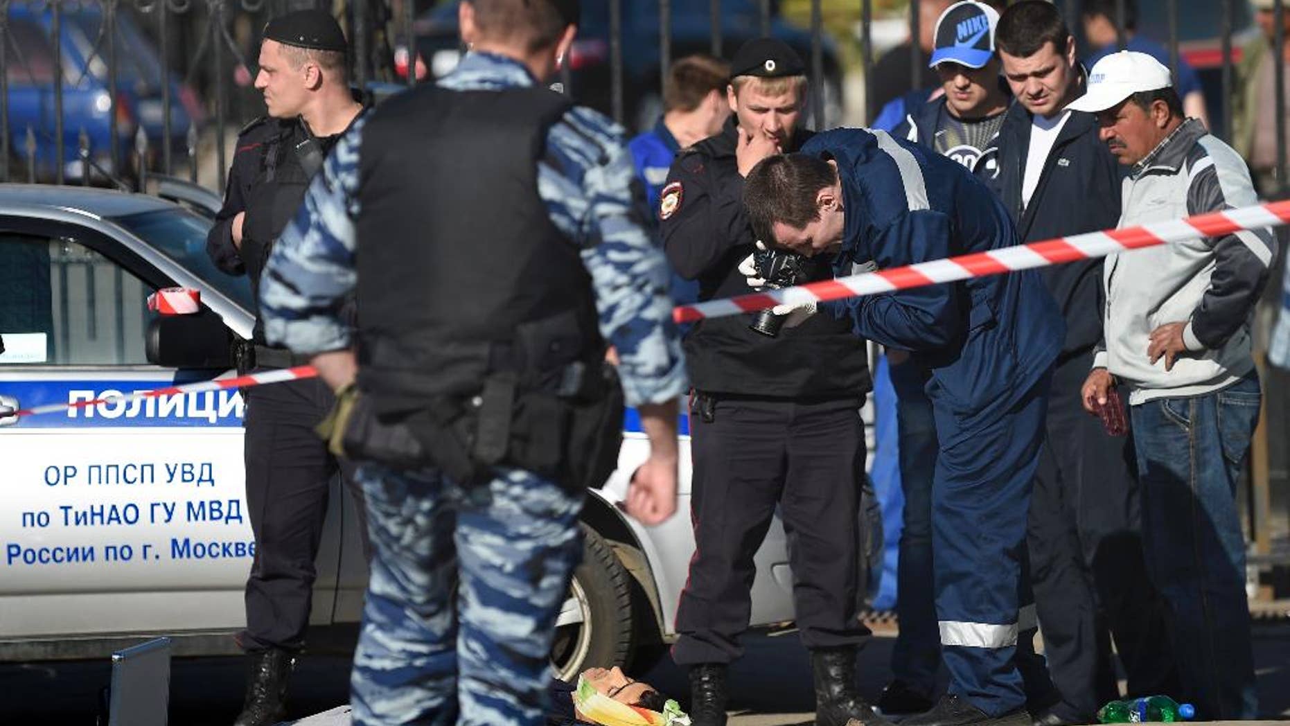 Police investigators work on the site of a brawl at the Khovanskoye cemetery in in Moscow, Russia, Saturday, May 14, 2016. Moscow police say a brawl at a cemetery involving up to 200 people has left two people dead and 10 wounded. Russian news reports cited police as saying the brawl was believed to have been about control over providing burial services at the sprawling Khovanskoye cemetery in southwest Moscow. (AP Photo)