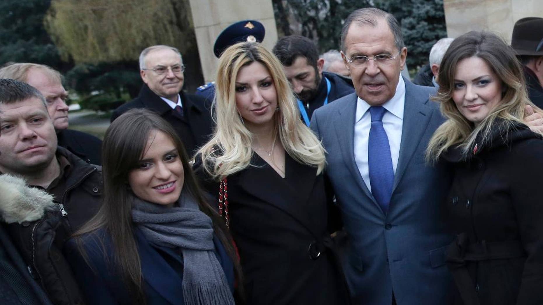 In this photo taken Monday, Dec. 12, 2016, Russian Foreign Minister Sergey Lavrov, second from right, poses for photos with members of a far-right pro-Russian group with Nemanja Ristic at first left, in Belgrade, Serbia. Serbian police have arrested two Serbs sought by Montenegro for alleged involvement in a pro-Russian plot to overthrow the Balkan country's government. Police said Friday that Nemanja Ristic and Predrag Bogicevic were arrested on an international warrant issued by Montenegro. It was not immediately clear when they could be extradited. (AP Photo, File)
