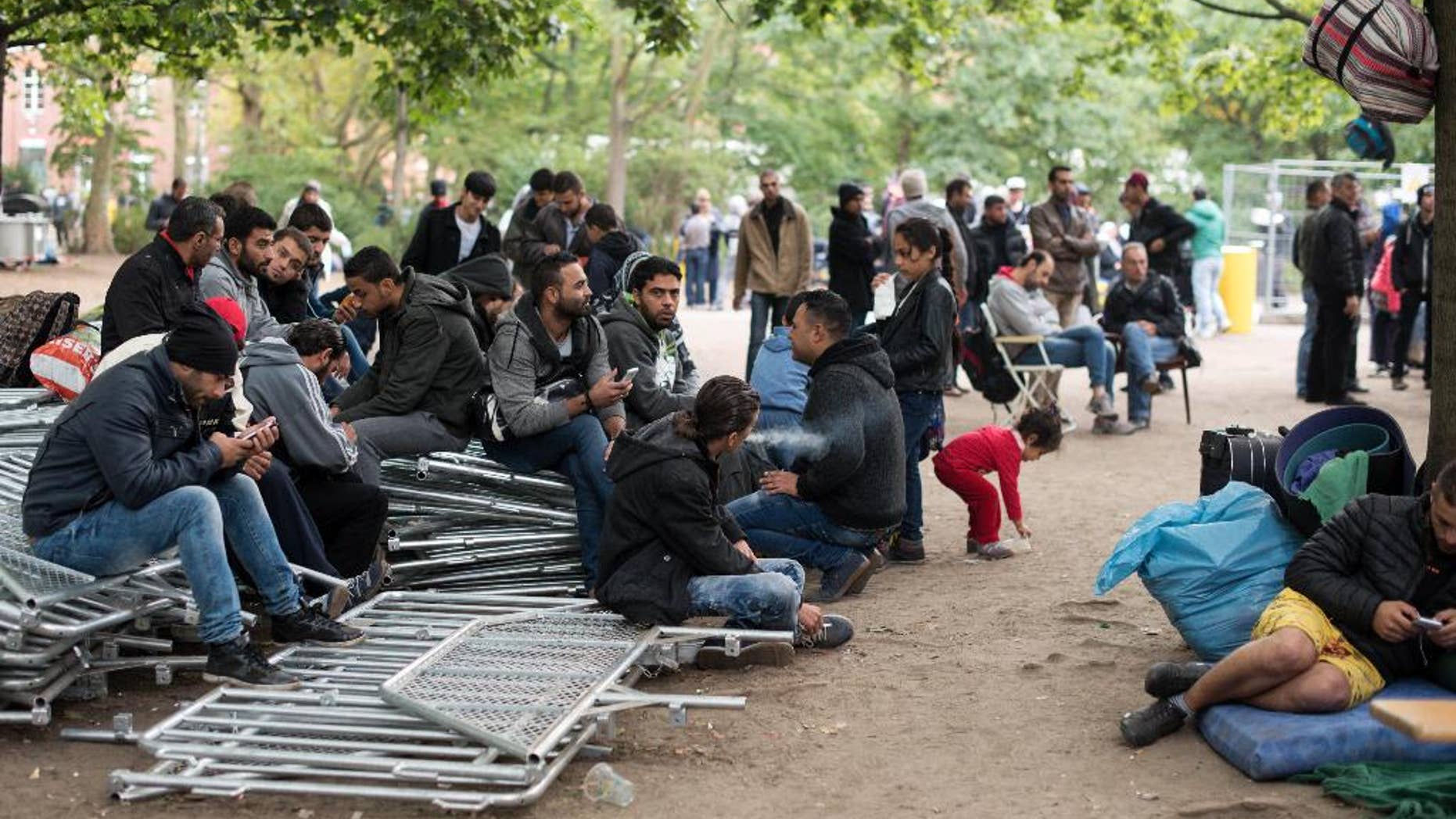 Refugees wait for registration outside the state office for health and social issues in Berlin, Germany, Friday, Sept. 25 2015. Every day hundreds of refugees have to wait here to be registered. (Bernd von Jutrczenka/dpa via AP)