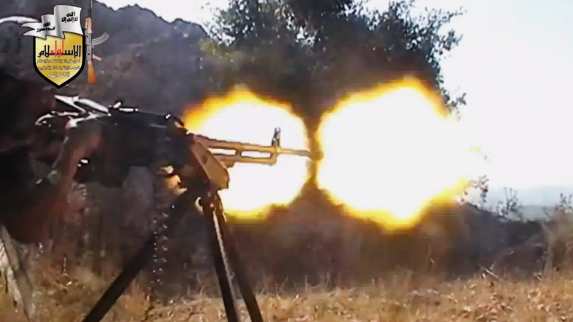 FILE - In this file image taken from Sunday, Aug. 11, 2013, video obtained from the Shaam News Network, which has been authenticated based on its contents and other AP reporting, a rebel fighter fires a gun in a valley in an unidentified location in Latakia province, Syria. Jihadi-led rebel fighters in Syria killed at least 190 civilians and abducted more than 200 during an offensive against pro-regime villages, committing a war crime, an international human rights group said Friday, Oct. 11, 2013. (AP Photo/Shaam News Network via AP Video, File)