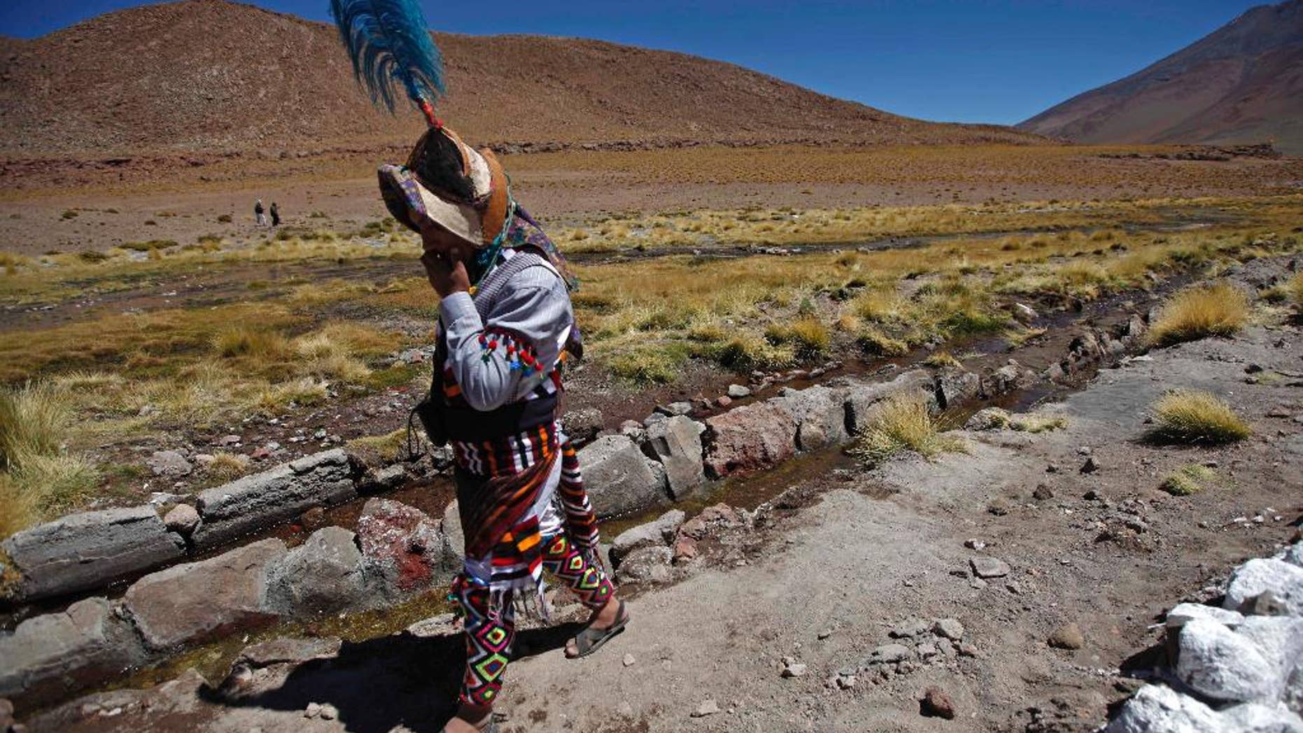 FILE - In this March 28, 2013, file photo, a Quechua indigenous man walks beside the stream of the Silala river in Potosi state, Bolivia. Bolivian President Evo Morales said on Saturday, March 26, 2016, that his country would sue Chile in the Netherlands-based International Court of Justice seeking to force Chile to pay compensation for using the Silala river in a border region. (AP Photo/Juan Karita, File)