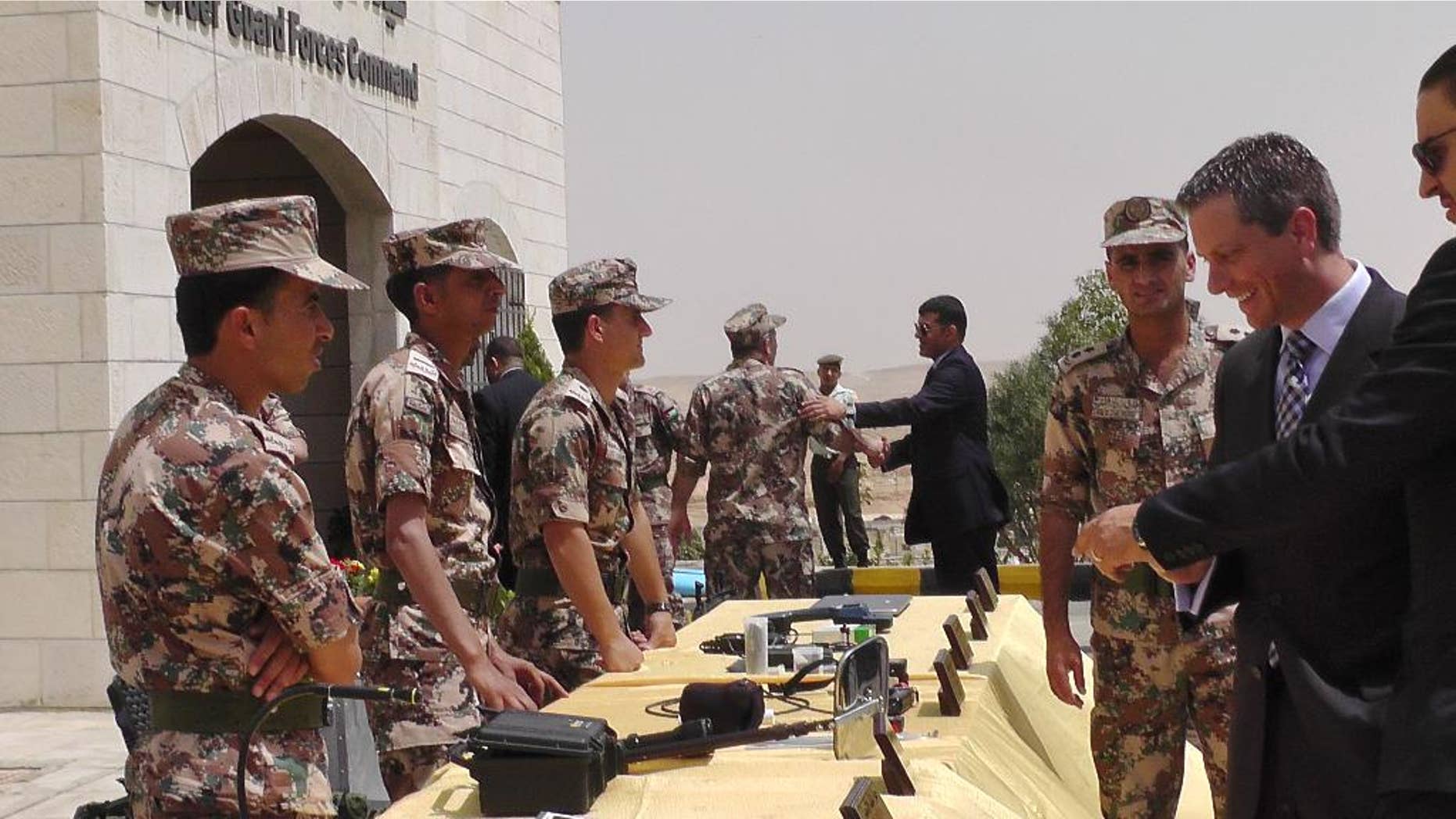 Members of the Jordanian border guard, left, stand behind a table where various devices for first detection of possible chemical or biological weapons materials are displayed for visitors at their headquarters near the city of Zarqa, Jordan on Monday, June 8, 2015. The devices are part of a partially U.S.-funded program to improve Jordan’s surveillance of its borders with Syria and Iraq and to prevent infiltration of militants, including from the extremist group Islamic State, as well as the possible influx of weapons. (AP Photos/Karin Laub)