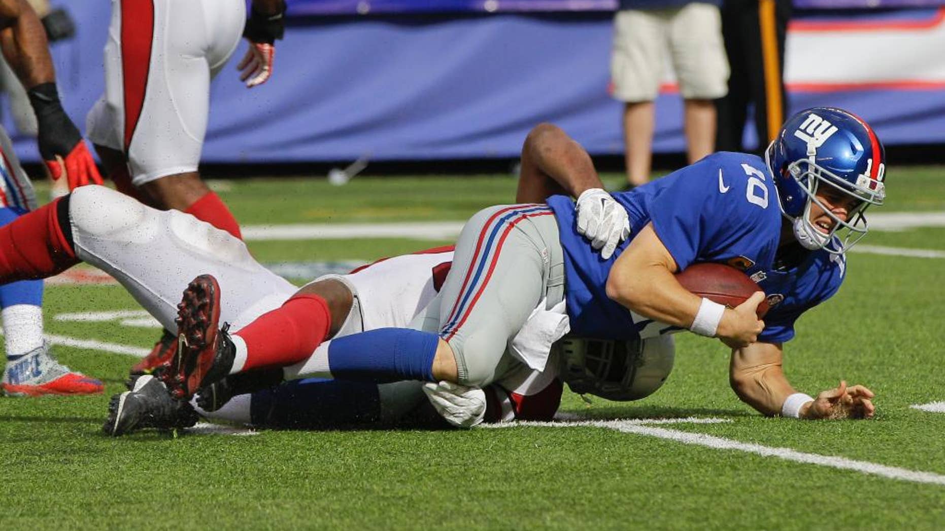 New York Giants quarterback Eli Manning (10) is sacked by Arizona Cardinals defensive end Calais Campbell during the second half of an NFL football game Sunday, Sept. 14, 2014, in East Rutherford, N.J. The Cardinals won the game 25-14. (AP Photo/Kathy Willens)