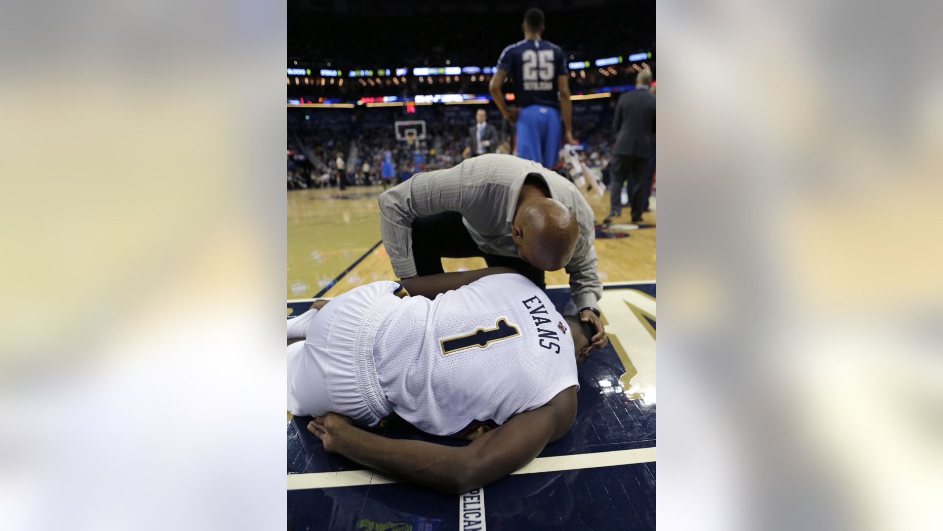 New Orleans Pelicans point guard Tyreke Evans (1) is tended to after coming down badly and hurting his ankle in the second half of an NBA basketball game against the Oklahoma City Thunder in New Orleans, Friday, Dec. 6, 2013. The Thunder won 109-95. (AP Photo/Gerald Herbert)