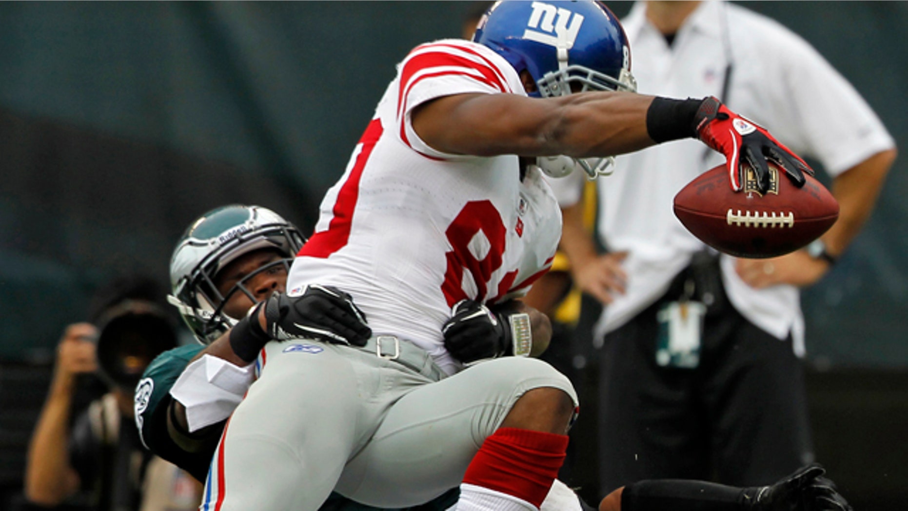 New York Giants wide receiver Victor Cruz (80) scores a touchdown as he leans over the goal line as Philadelphia Eagles strong safety Jarrad Page, left, and Philadelphia Eagles cornerback Nnamdi Asomugha (24) make the tackle in the second half of an NFL football game on Sunday, Sept. 25, 2011, in Philadelphia. Giants won 29-16. (AP Photo/Alex Brandon)