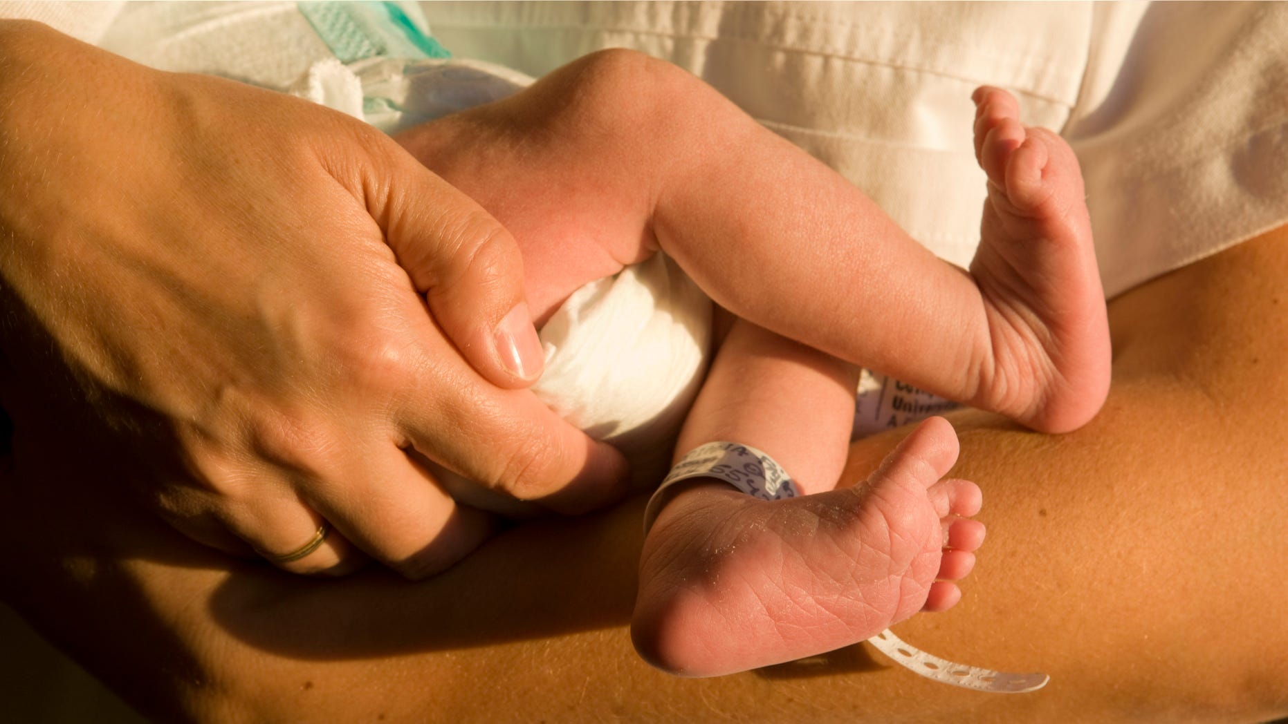 A nurse embraces and teaches the foot of a newborn baby at University Hospital region of A Coruna, Galicia, 26th October 2010. (Photo by Xurxo Lobato/Cover/Getty Images)
