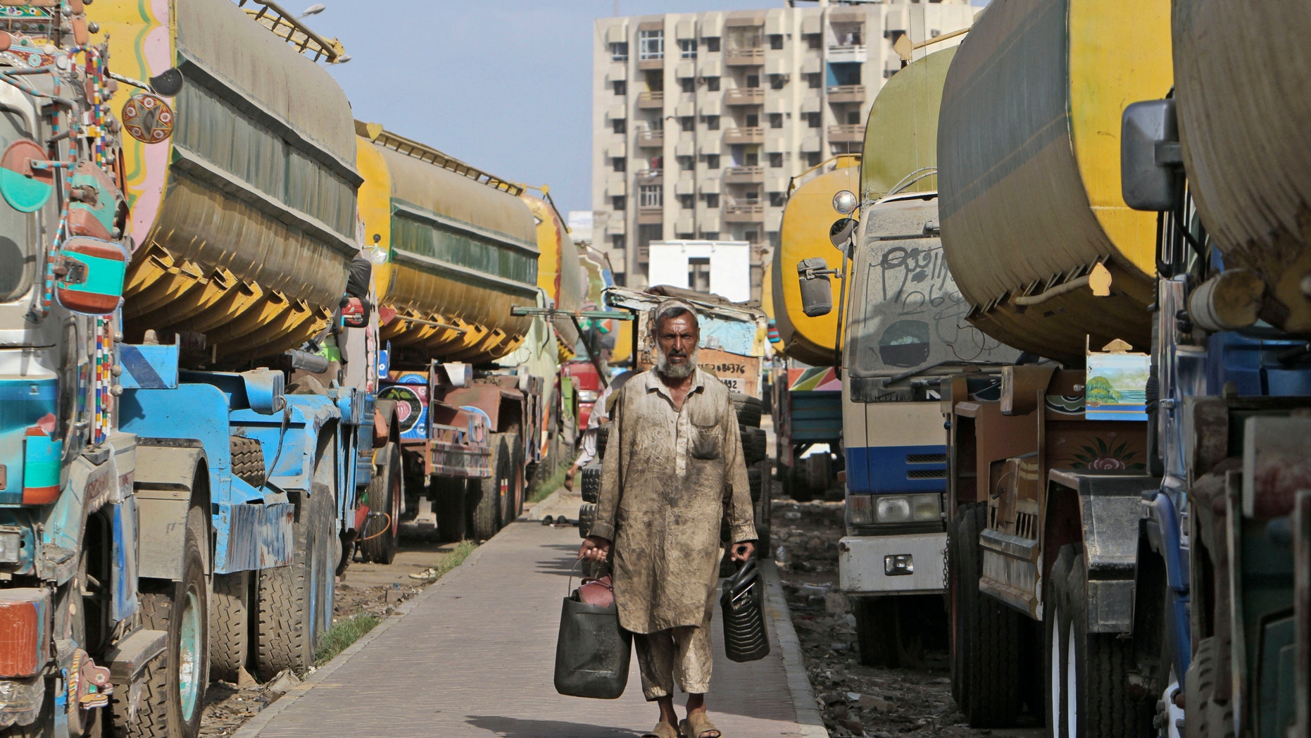 May 19, 2012: Pakistani mechanic Arbaaz khan,walks between oil tankers, used to transport NATO fuel supplies to Afghanistan, in Karachi, Pakistan.