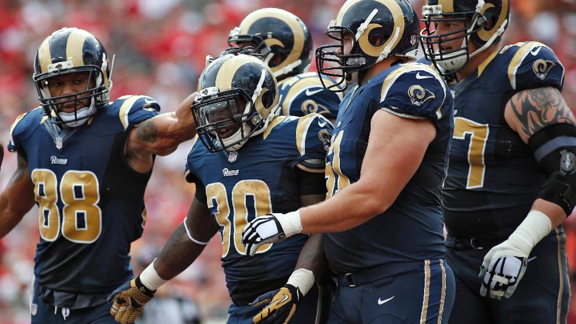 St. Louis Rams running back Zac Stacy (30) celebrates with teammates, including tight end Lance Kendricks (88) and center Tim Barnes (61), after scoring against the Tampa Bay Buccaneers during the first quarter of an NFL football game Sunday, Sept. 14, 2014, in Tampa, Fla. (AP Photo/Brian Blanco)