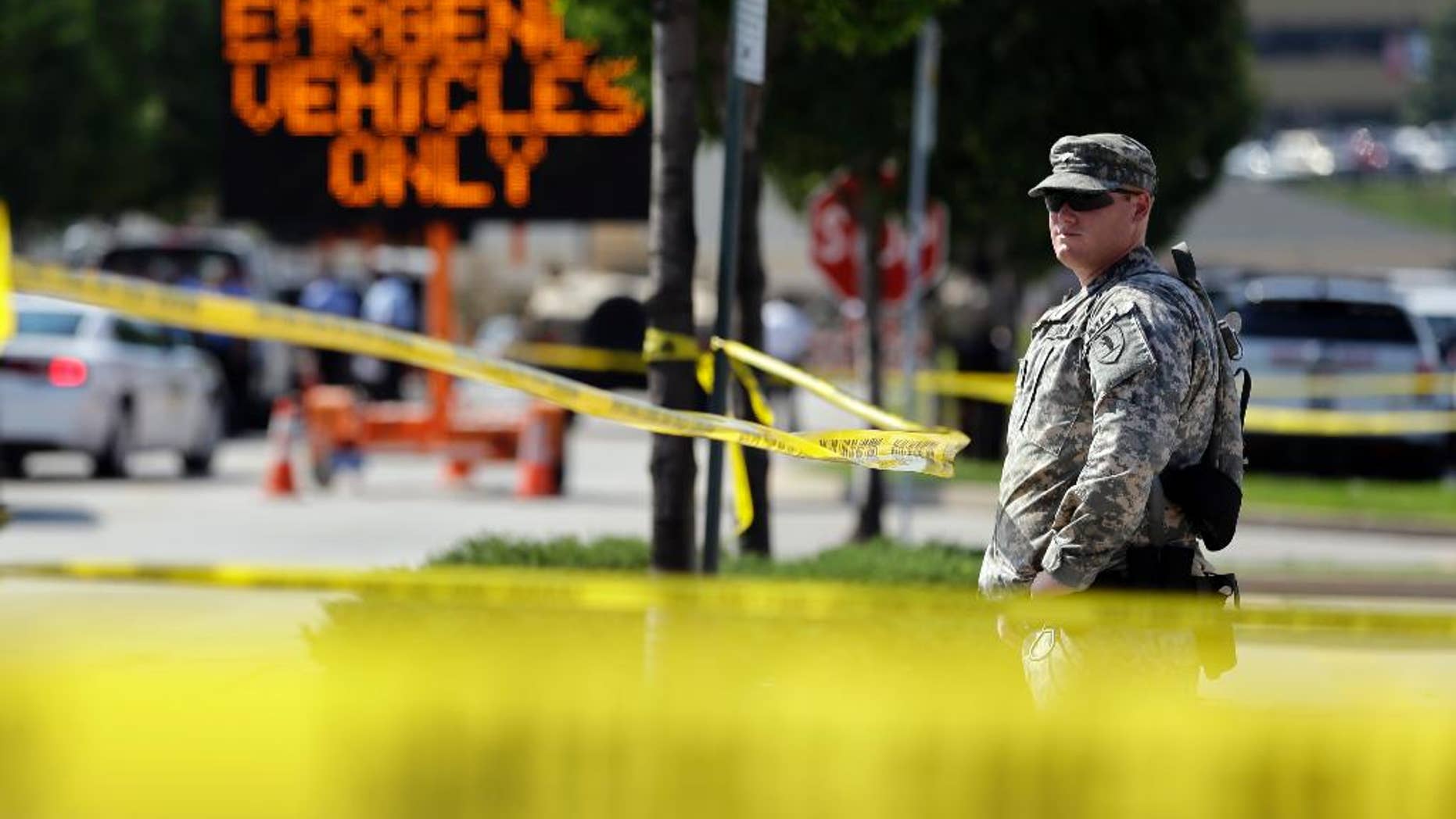 A member of the Missouri National Guard stands guard at a police command post Tuesday, Aug. 19, 2014, in Ferguson, Mo. Ferguson's leaders urged residents Tuesday to stay home after dark to "allow peace to settle in" and pledged several actions to reconnect with the predominantly black community in the St. Louis suburb where the fatal shooting of 18-year-old Michael Brown has sparked nightly clashes between protesters and police. (AP Photo/Jeff Roberson)