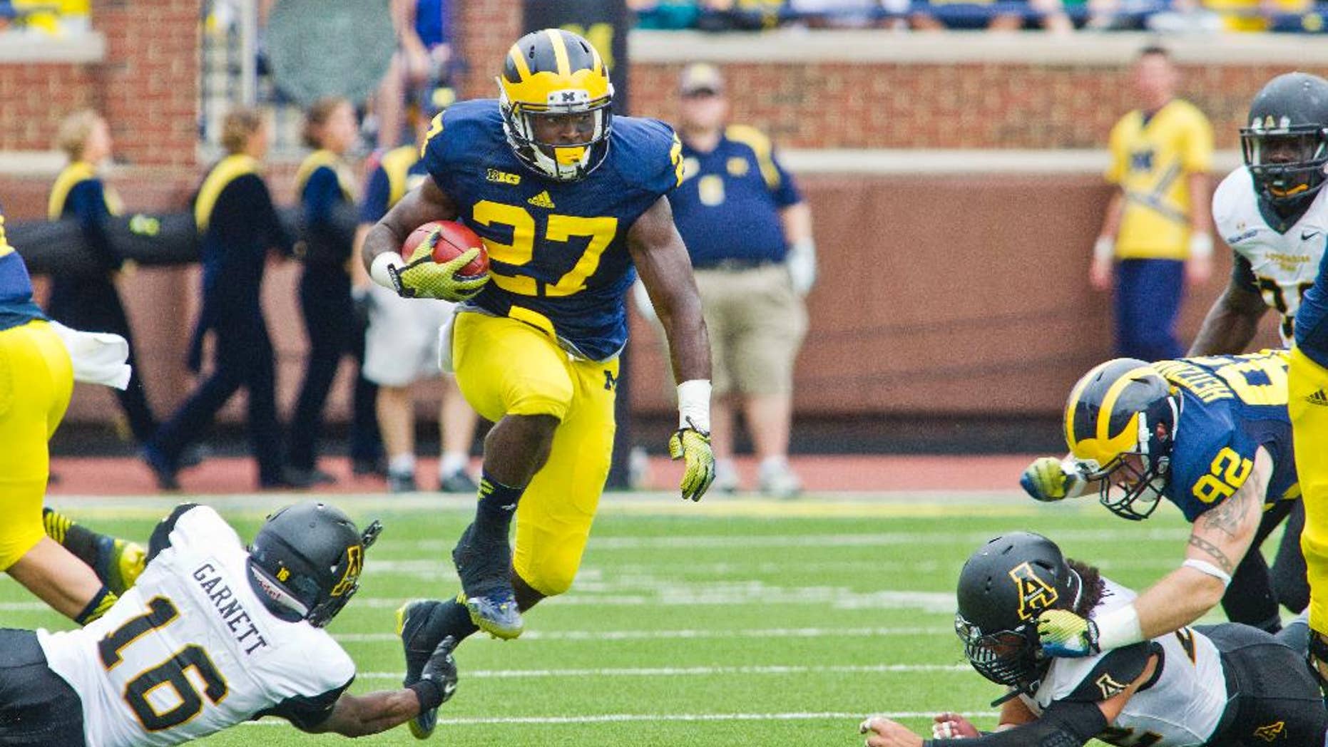 Appalachian State defensive back Treyon Garnett (16) fails to stop Michigan running back Derrick Green (27) in the third quarter of an NCAA college football game in Ann Arbor, Mich., Saturday, Aug. 30, 2014. Michigan won 52-14. (AP Photo/Tony Ding)
