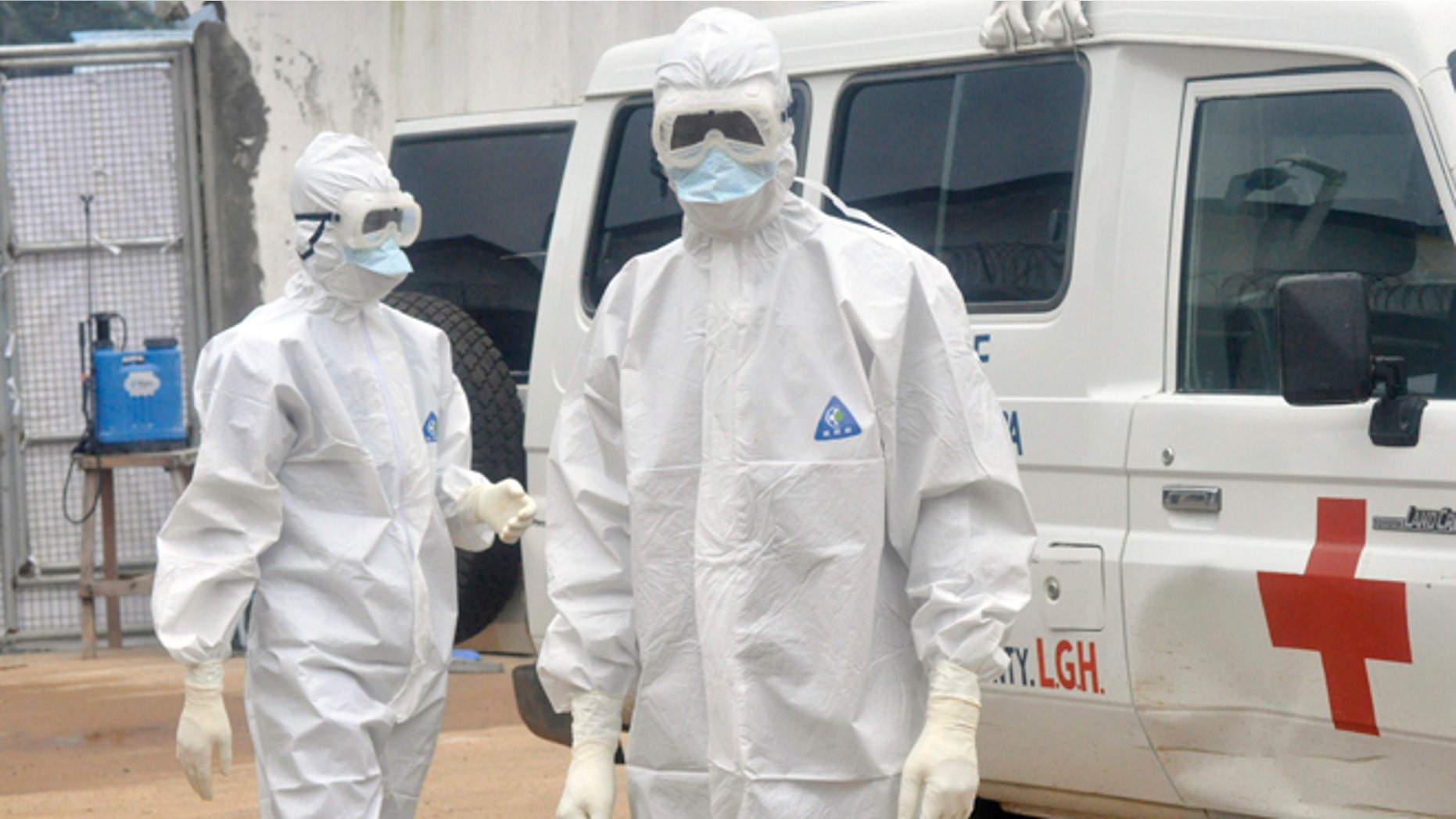Health workers wearing protective gear wait to carry the body of a person suspected to have died from Ebola, in Monrovia, Liberia, Monday Oct. 13, 2014. Some nurses in Liberia defied calls for a strike on Monday and turned up for work at hospitals amid the worst Ebola outbreak in history. In view of the danger of their work, members of the National Health Workers Association are demanding higher monthly hazard pay. The association has more than 10,000 members, though the health ministry says only about 1,000 of those are employed at sites receiving Ebola patients. (AP Photo/Abbas Dulleh)