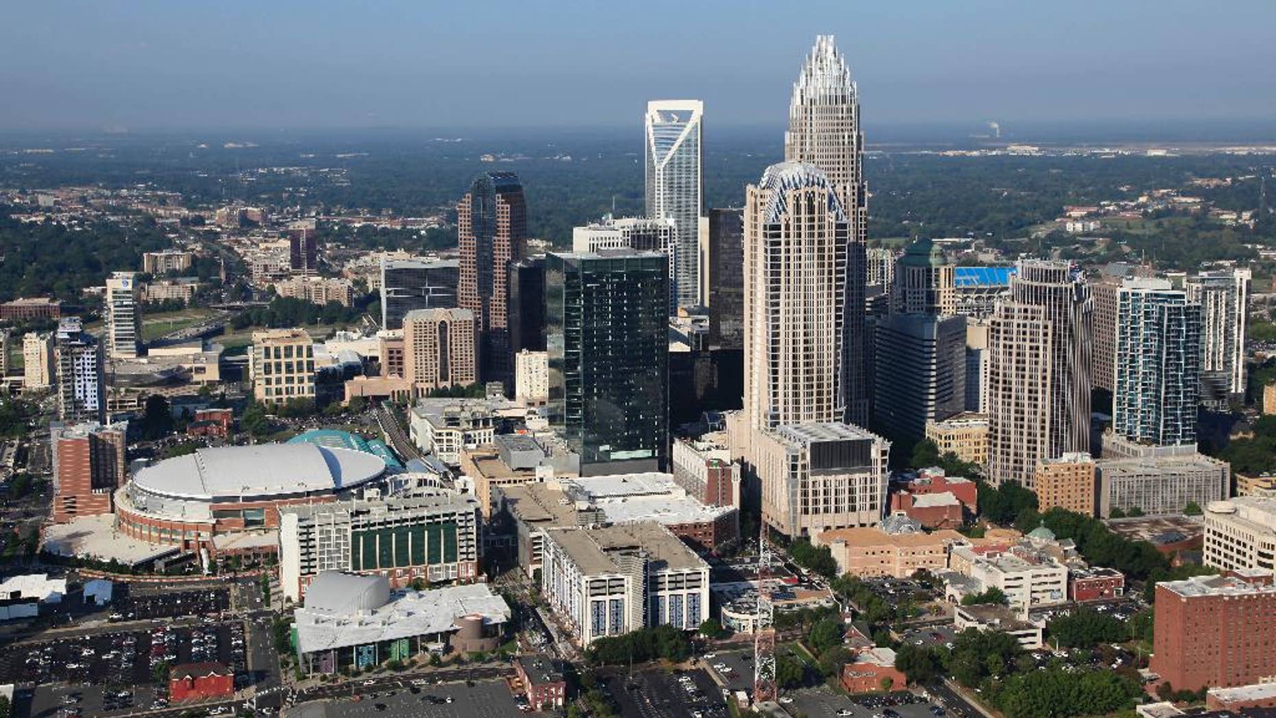 In this Aug. 16, 2012 file photo, the Time Warner Cable Arena is shown on left of downtown Charlotte, N.C. To much of the world, Charlotte is the Queen City, a gleaming downtown, state-of-the-art stadiums, sparkling new mass transit, the nation's banking capital. But a very different Charlotte came into the spotlight in the past few days. Move outside the city's core and there are neighborhoods like the one where a police officer shot and killed a black man, Keith Scott, Sept. 20, 2016, setting off violent protests.(AP Photo/Chuck Burton)