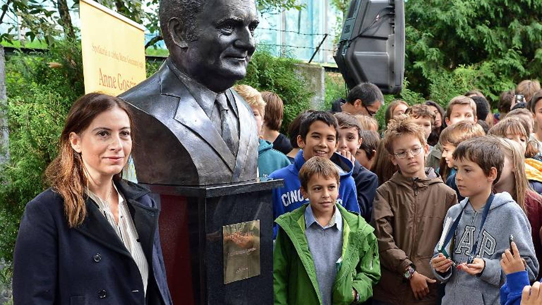 Anne Goscinny (L), daughter of the late French comic book writer Rene Goscinny, unveils a sculpture of her father at the French high school in Warsaw on September 25, 2013.