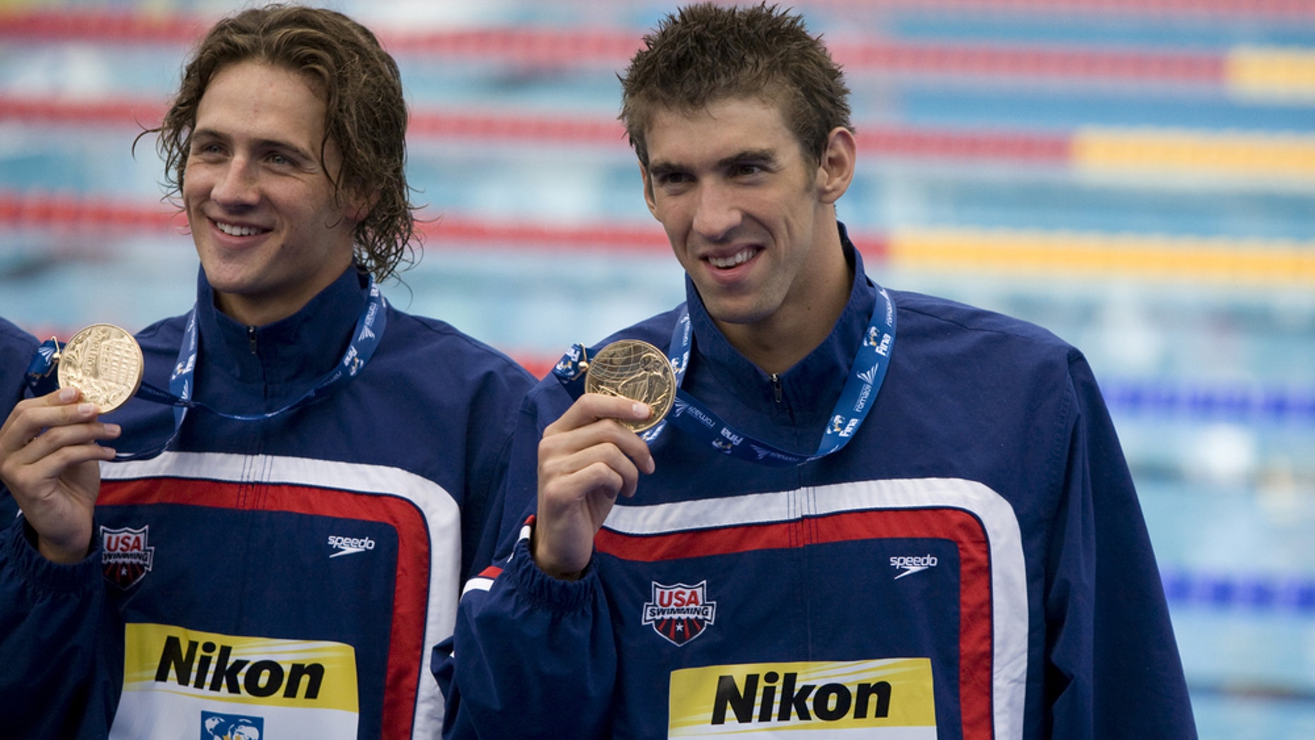 American swimmers — and rivals — Ryan Lochte and Michael Phelps hold gold medals won by Team USA during the 2009 World Aquatics Championships in Rome, Italy.