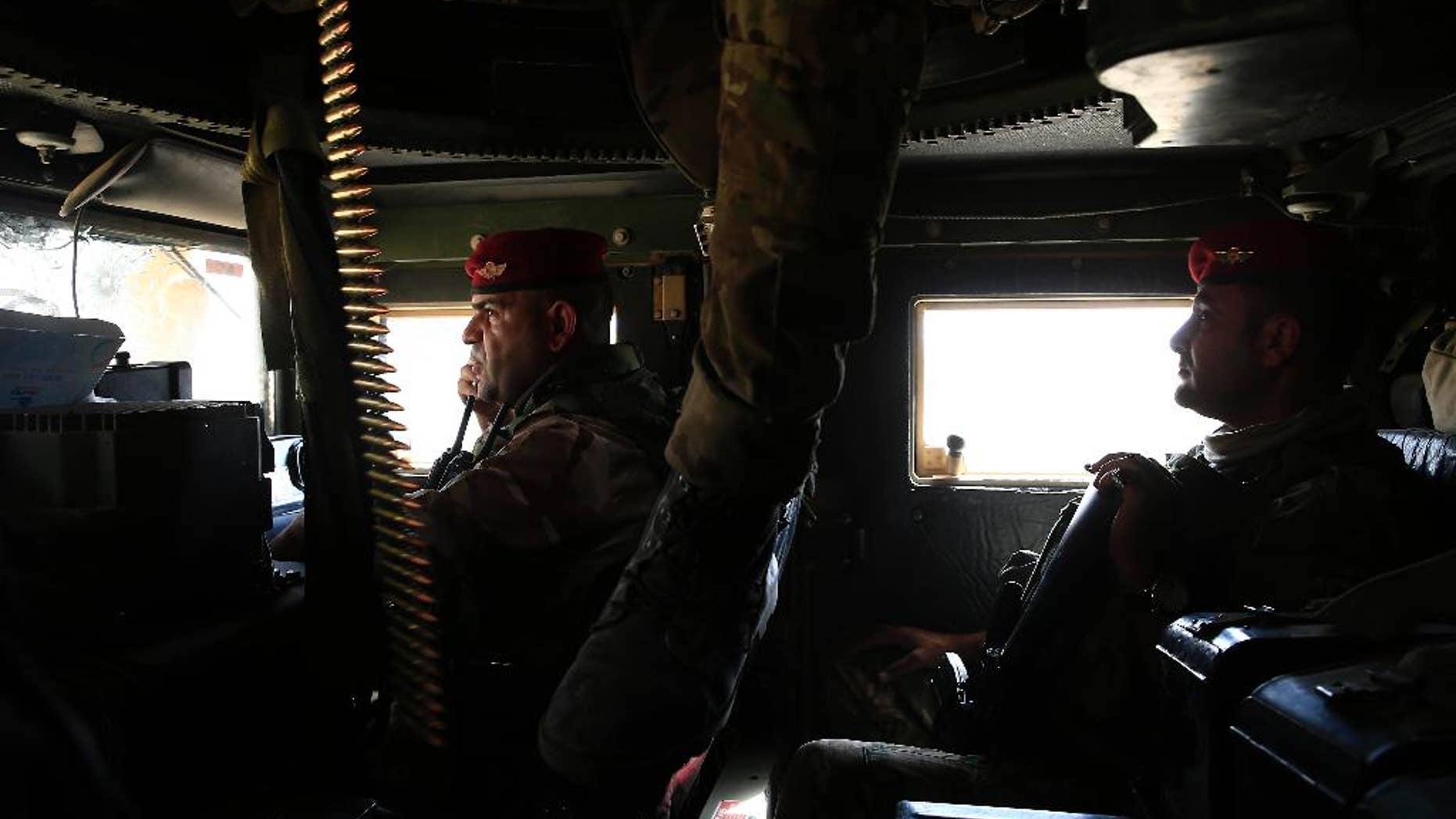 Iraqi soldiers drive towards the frontline in a humvee outside the town of Qayyarah on Tuesday, Oct. 4, 2016. Qayyarah has become an important staging ground for military and humanitarian efforts ahead of the Mosul operation. (AP Photo/Bram Janssen)