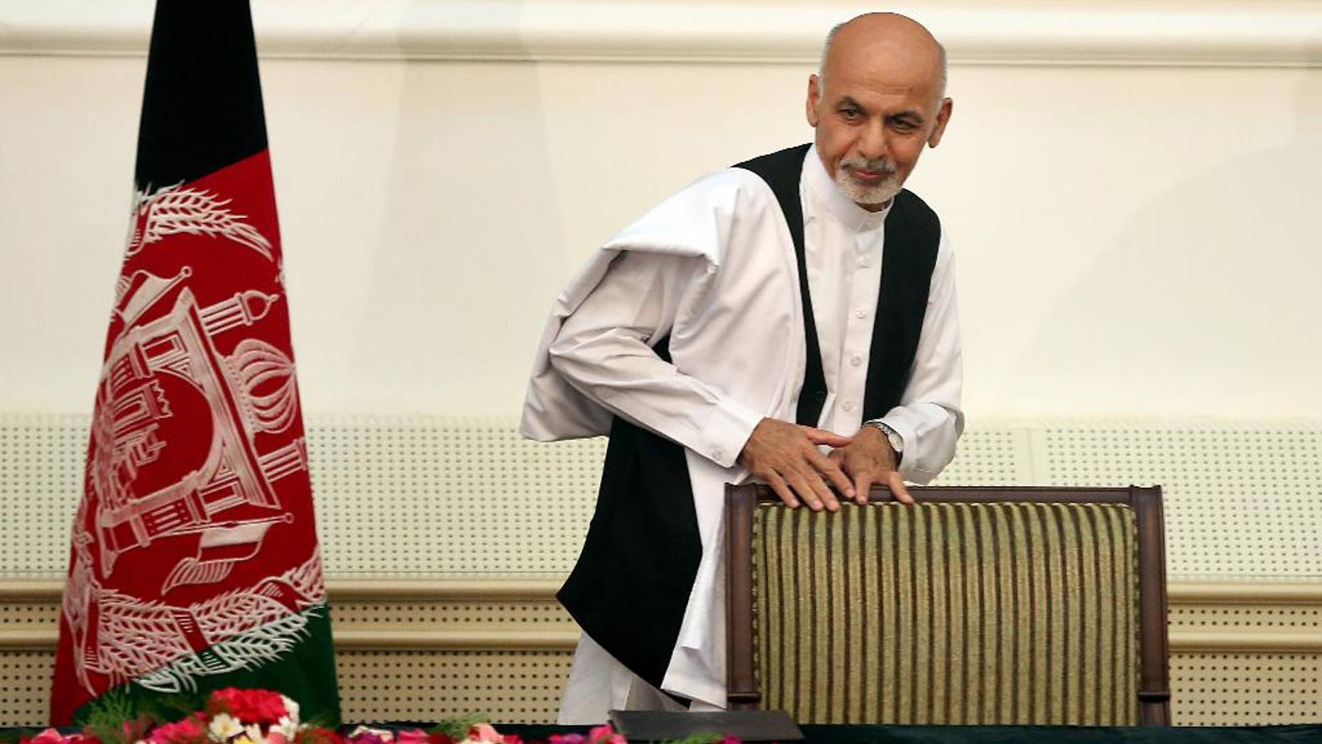 Afghanistan's presidential election candidate Ashraf Ghani Ahmadzai leaves after signing a power-sharing deal at the presidential palace in Kabul, Afghanistan, Sunday, Sept. 21, 2014. Ahmadzai, who will become president, and Abdullah Abdullah signed the national unity government deal as outgoing President Hamid Karzai watched.(AP Photo/Massoud Hossaini)