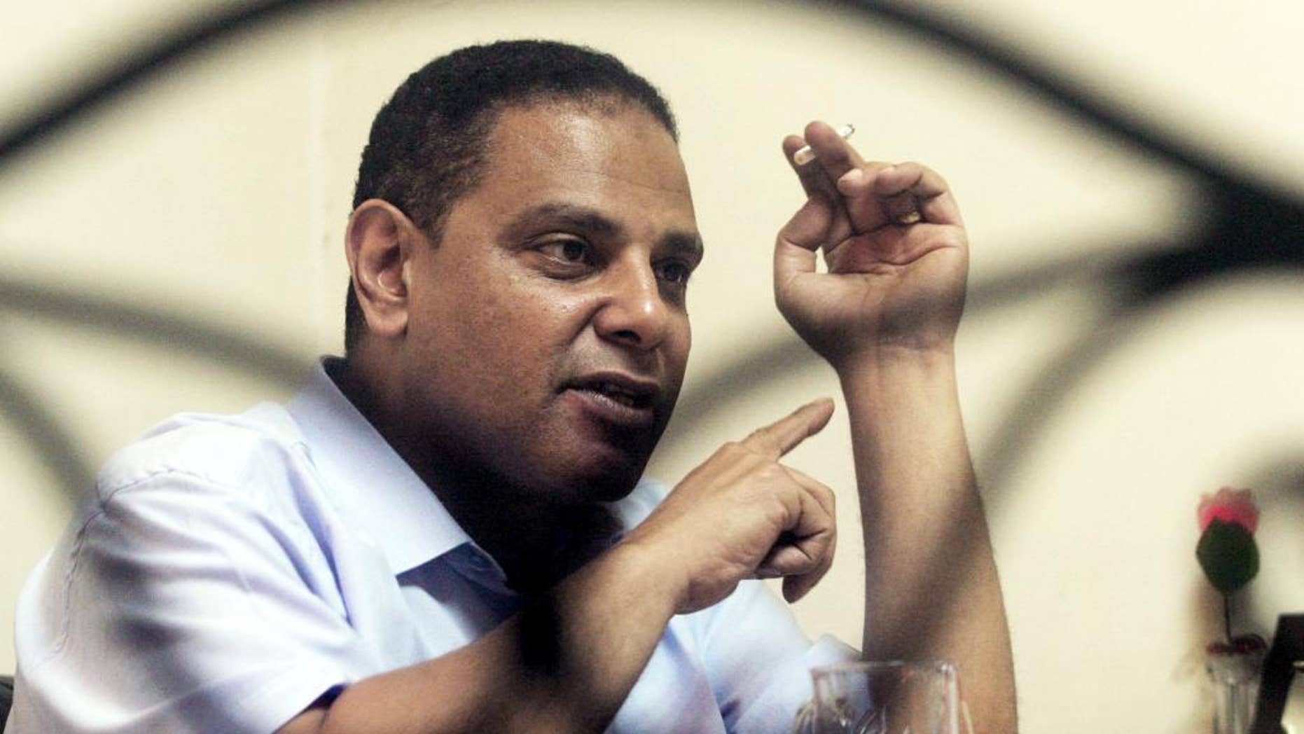 FILE - In this June 26, 2006 file photo, Alaa al-Aswany, the author of the "The Yacoubian Building," speaks during an interview with The Associated Press in Cairo, Egypt. Al-Aswany said Sunday, Dec. 13, 2015, that Egyptian authorities have pressured a cultural center to cancel an event where he was scheduled to talk about how the government manipulates the public with theories that the world is conspiring against Egypt. He told The AP that “freedom of expression is at its lowest point, worse than in the days of Hosni Mubarak.” (AP Photo/Petros Giannakouris, File)