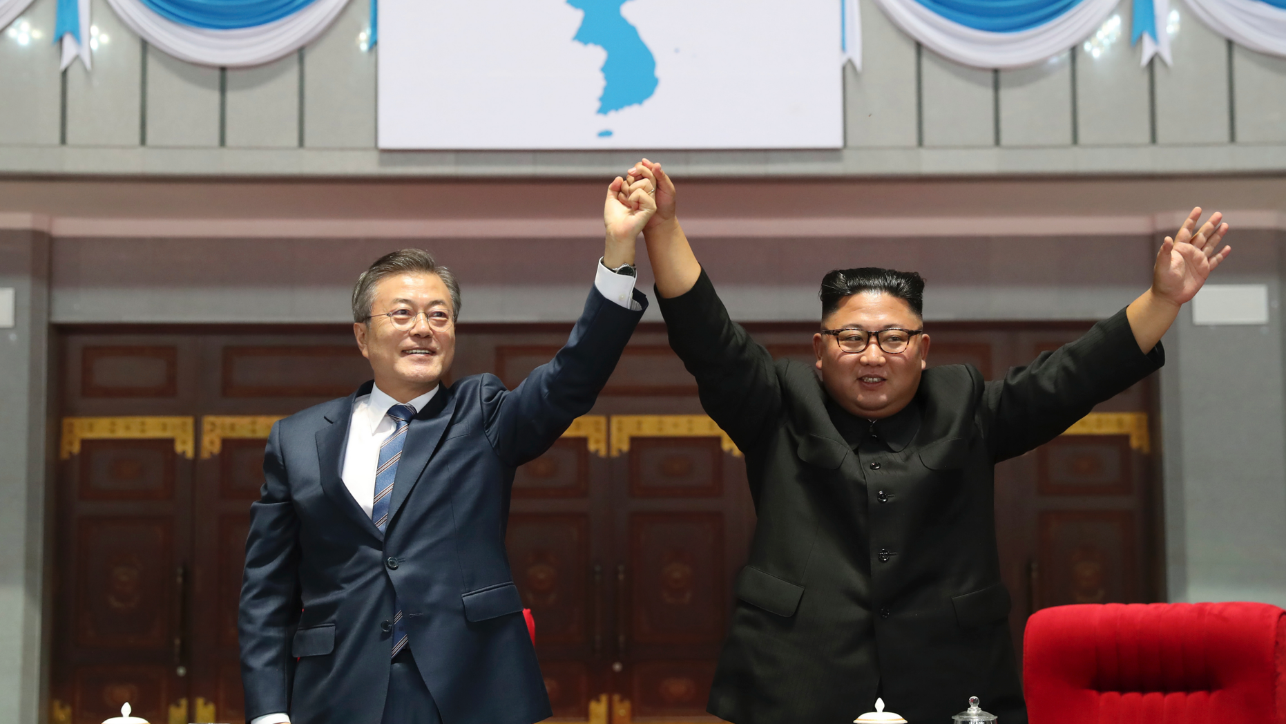 South Korean President Moon Jae-in and North Korean leader Kim Jong Un raise their hands after watching the mass games performance of "The Glorious Country" at May Day Stadium in Pyongyang, North Korea, Wednesday, Sept. 19, 2018. (Pyongyang Press Corps Pool via AP)